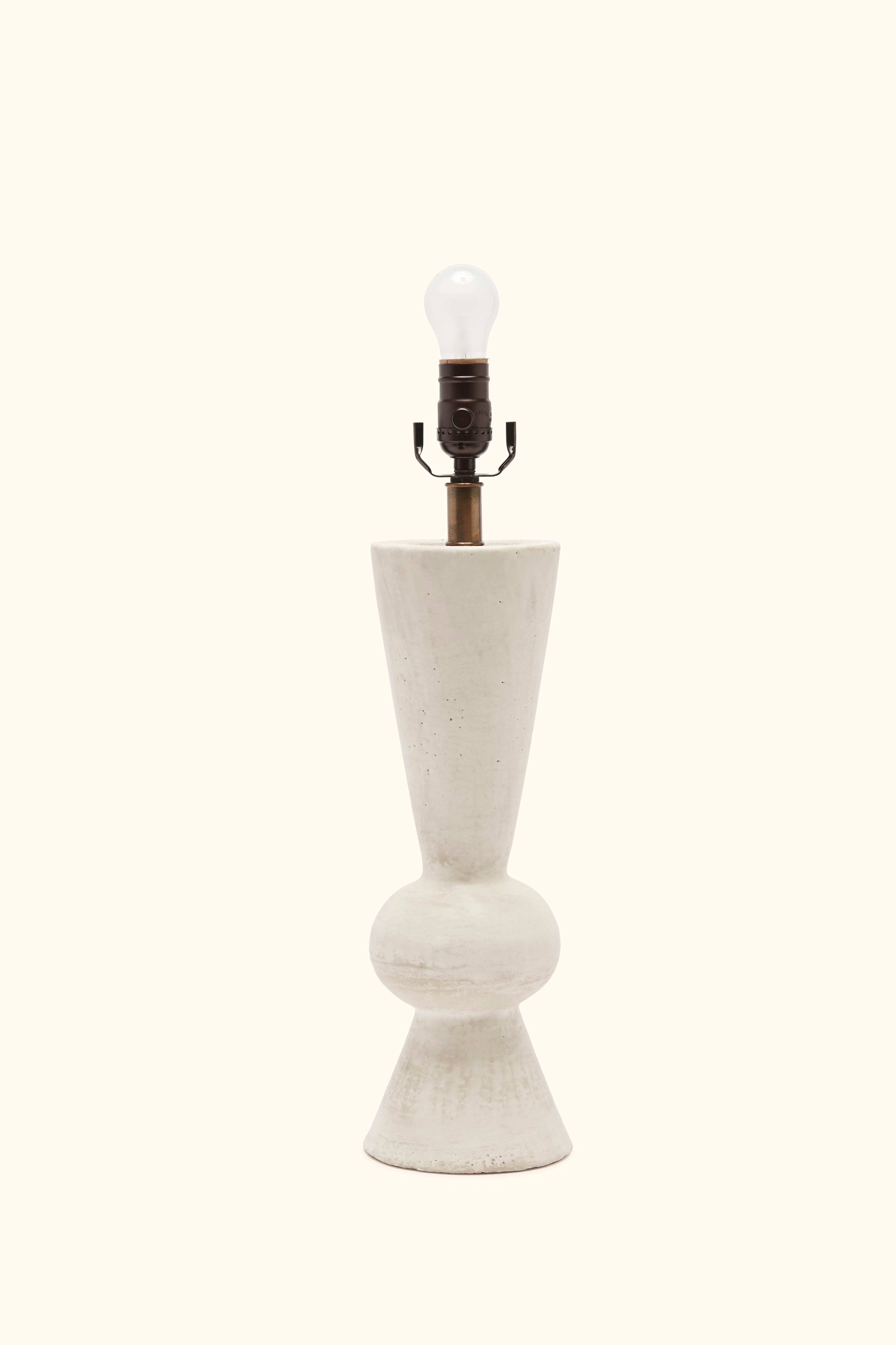 The Octavious lamp in bone glaze is handmade studio pottery by ceramic artist by Danny Kaplan. Linen shade included.

Born in New York City and raised in Aix-en-Provence, France, Danny Kaplan’s passion for ceramics was shaped by early exposure to