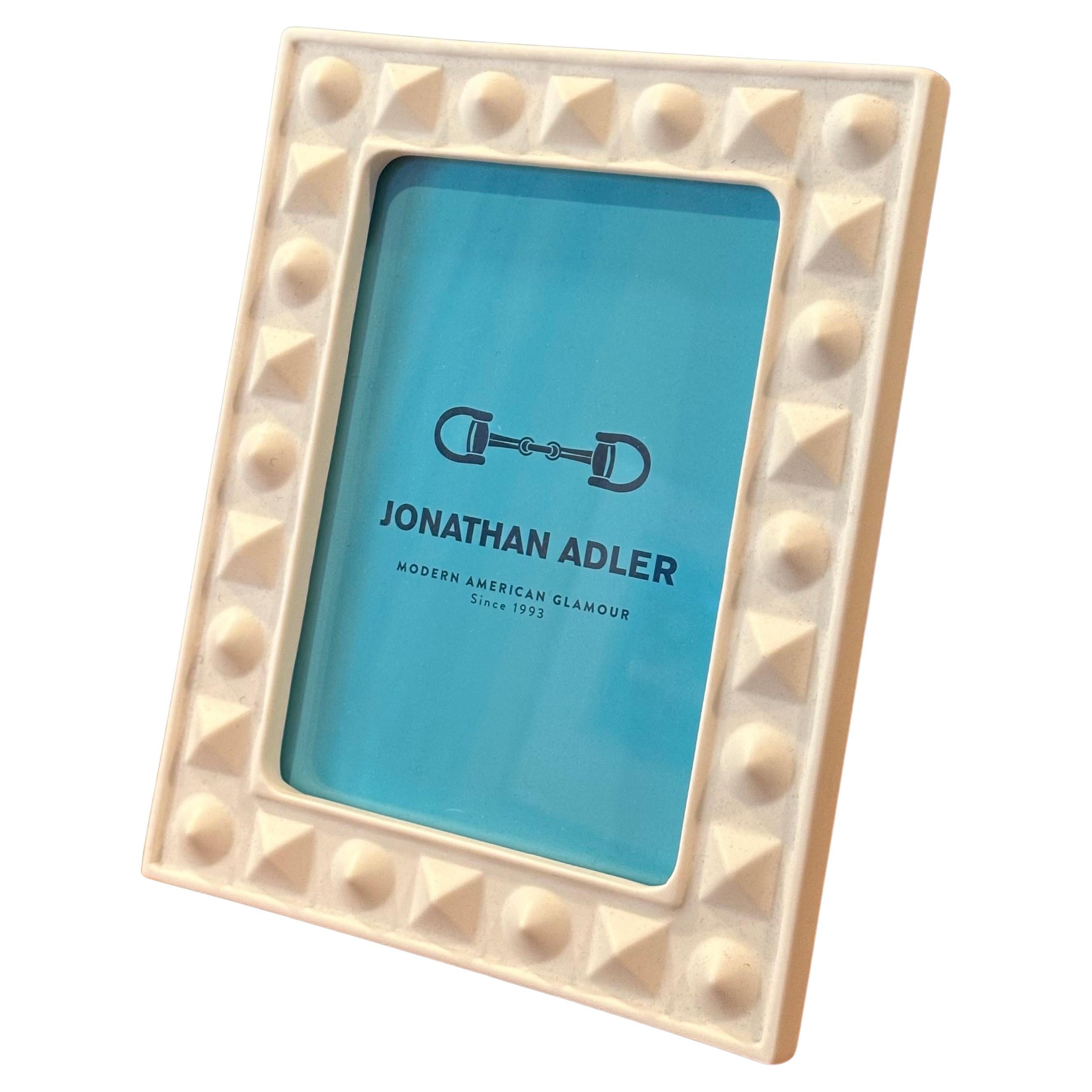 Precioso marco de cerámica blanca de Jonathan Adler, nuevo en su caja original, alrededor de la década de 2000.  El marco tiene capacidad para una fotografía 5x7 y mide 7 