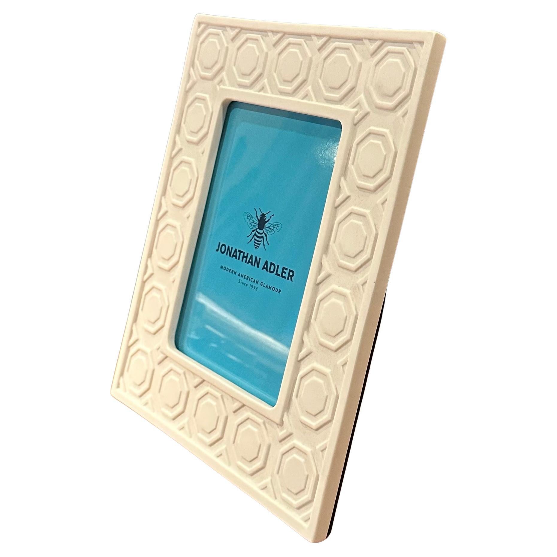 Un magnifique cadre photo en céramique blanche de Jonathan Adler, neuf dans sa boîte d'origine, circa 2000s.  Le cadre peut contenir une photographie de 5