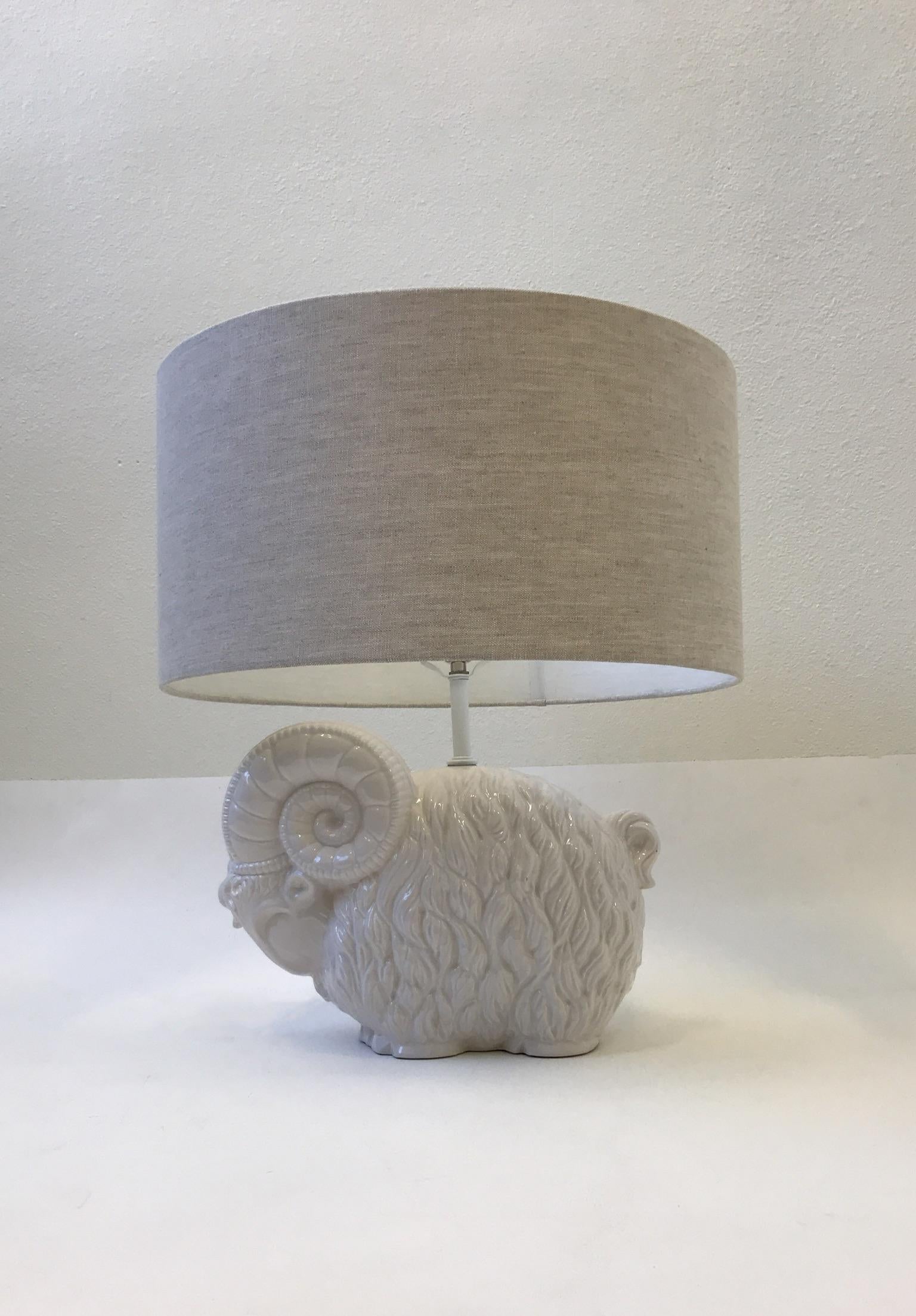 A beautiful 1970’s white ceramic table lamp designed by Hager. The lamp has been newly rewired with new polish nickel socket and new oatmeal linen shade. 
Dim: Overall Dimensions- 22.5” high 20” diameter. 
 Just the Ram- 16” wide 11” high 7” deep.