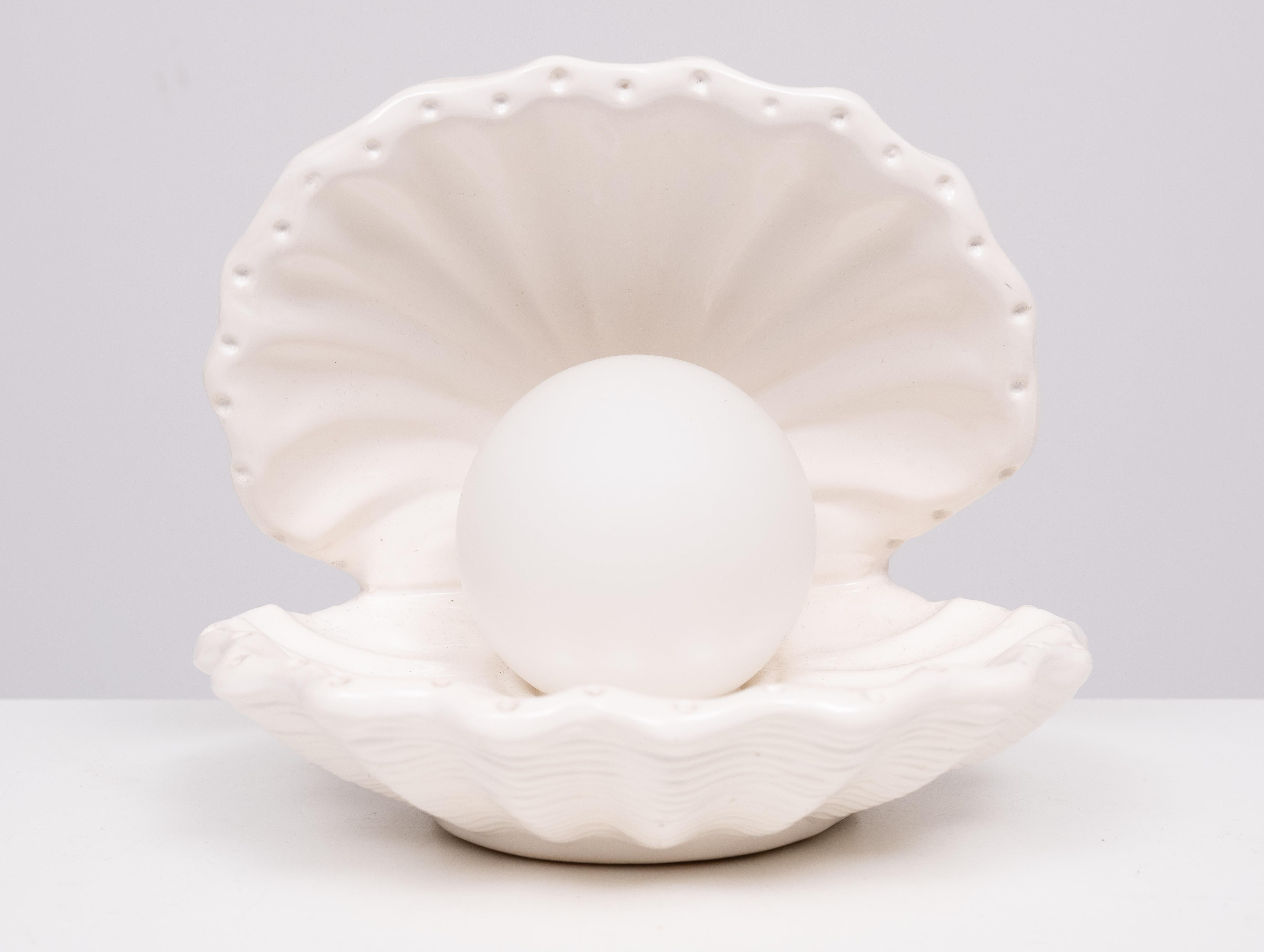 Very nice table lamp .White Ceramic Shell shaped . The Pearl 
is the light . 1970s 