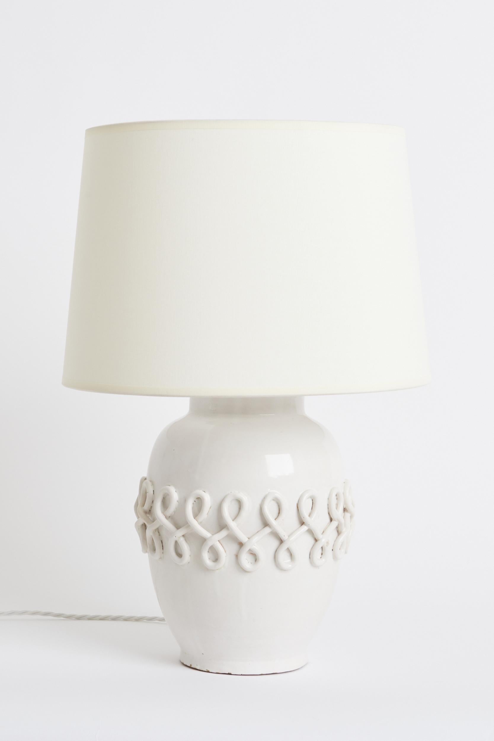 Lampe de table Art déco en céramique blanche
France, Circa 1950
Avec l'abat-jour : 52,5 cm de haut par 35,5 cm de diamètre
Base de la lampe uniquement : 35 cm de haut par 20 cm de diamètre