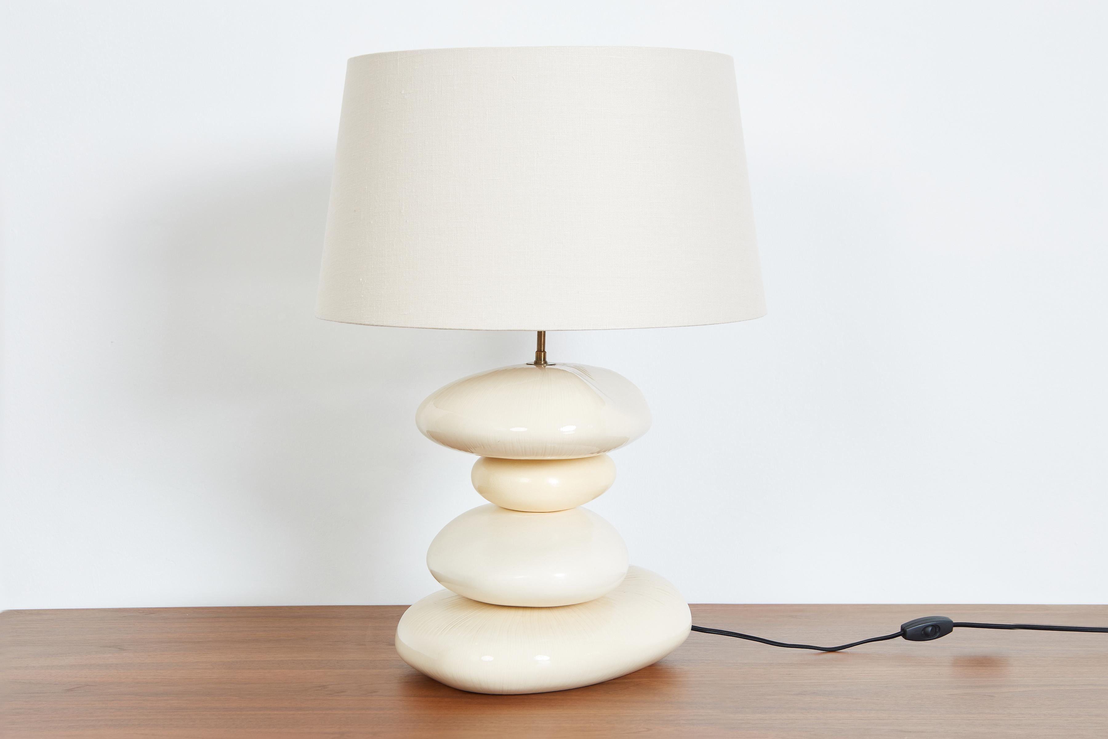 Incroyable lampe de table en céramique française des années 1960 avec des formes organiques variées dans des tons de crème et de blanc. 
Nouveau câblage avec abat-jour en lin