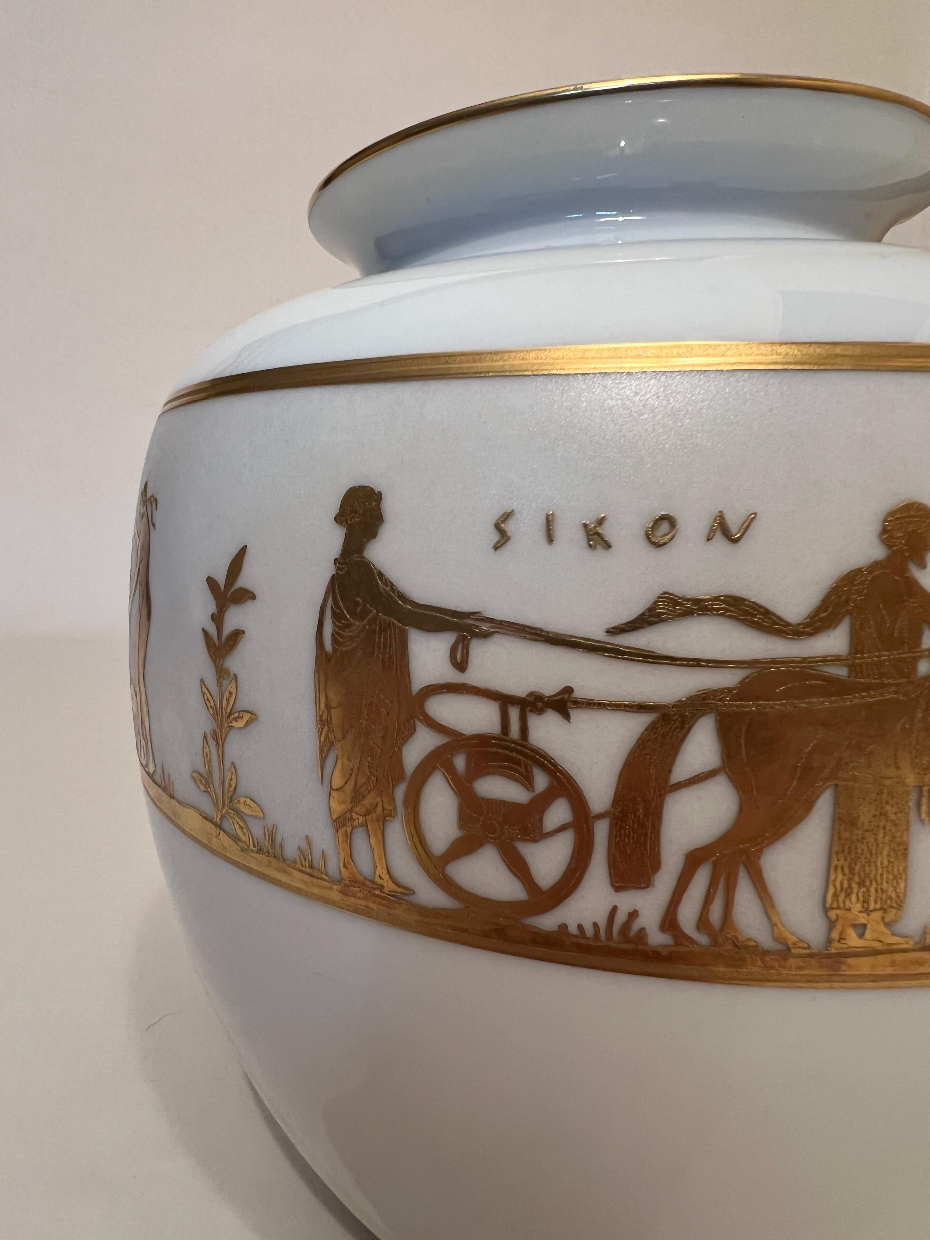 Superb white and gold ceramic vase with screen-printing depicting mythological scenes and the inscription SIKON, suggesting that the scenes speak of the harvest, typical in Greece, of figs. 
Famous for its silverware, the Florentine 'Finzi'