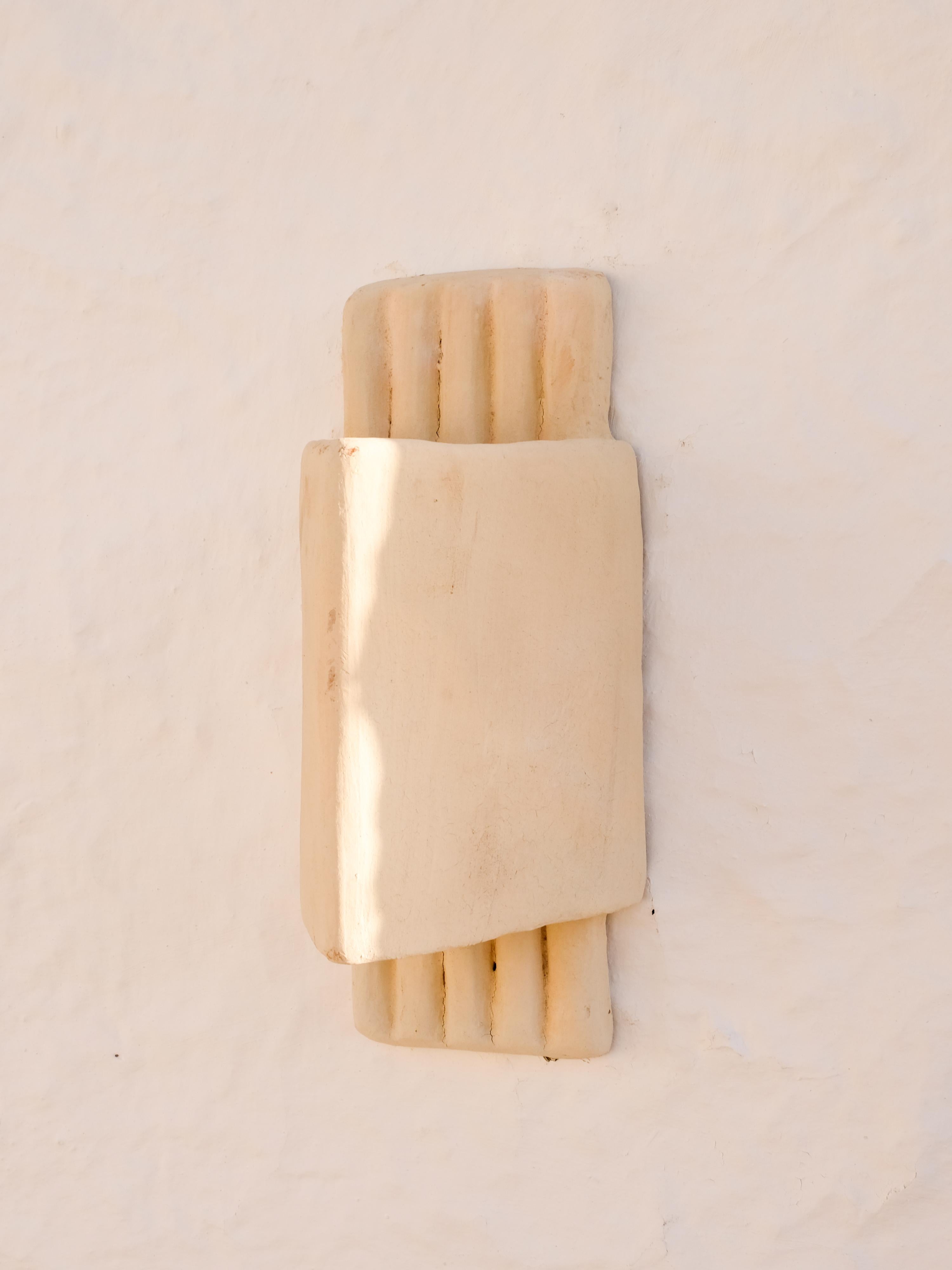 - Handbuilt white ceramic wall light
- slip applied with natural pigments as whitewash with water
- made of clay collected from the potter's surroundings.
- made in the Moroccan Rif mountains by the potter Houda.
- co-created by the potter Houda x