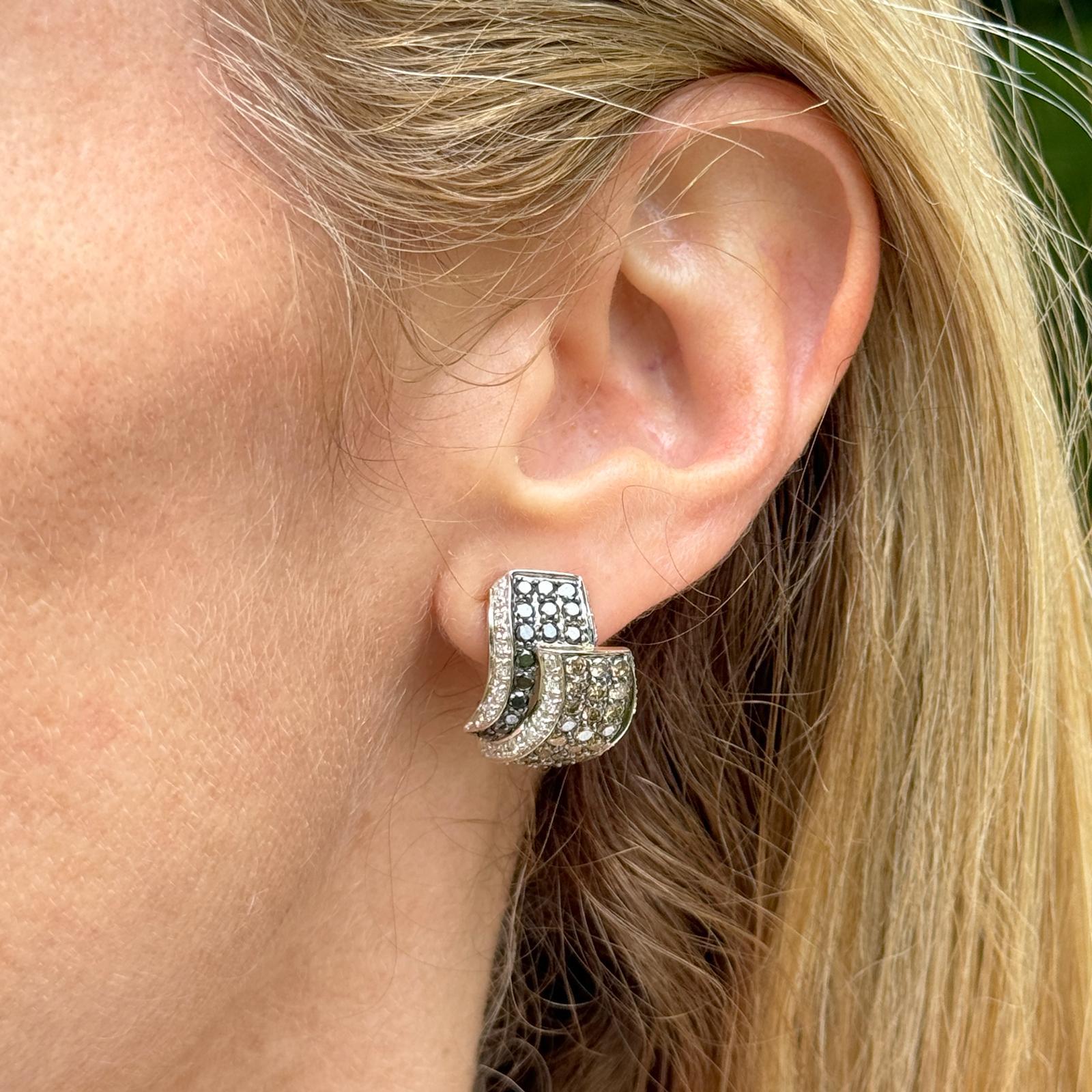 The modern black, white, and champagne diamond earrings set in 14 karat yellow gold are a contemporary accessory that exudes elegance and sophistication.
These earrings feature a combination of black, white, and champagne diamonds weighing