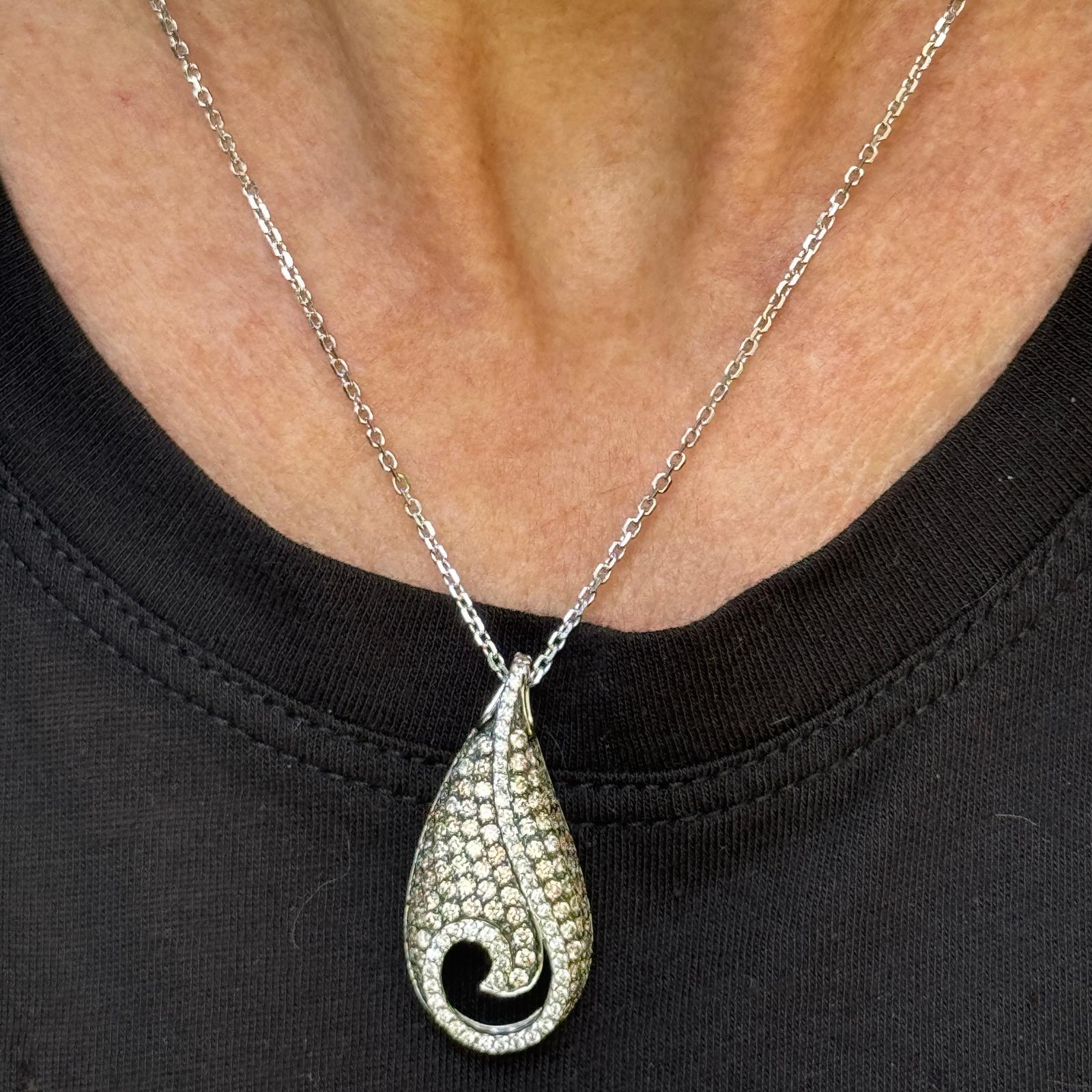 Dieser atemberaubende Diamantanhänger aus 14 Karat Weißgold ist eine wunderbare Mischung aus Raffinesse und Glanz. Der Anhänger enthält 42 runde Diamanten im Brillantschliff, darunter eine Mischung aus weißen und champagnerfarbenen Steinen, mit