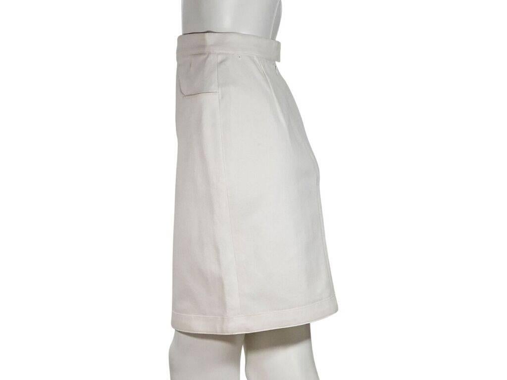 Product details:  White denim cotton skirt by Chanel.  Banded waist.  Scoop waist pockets.  Concealed back zip closure.  Label size FR 38.  25