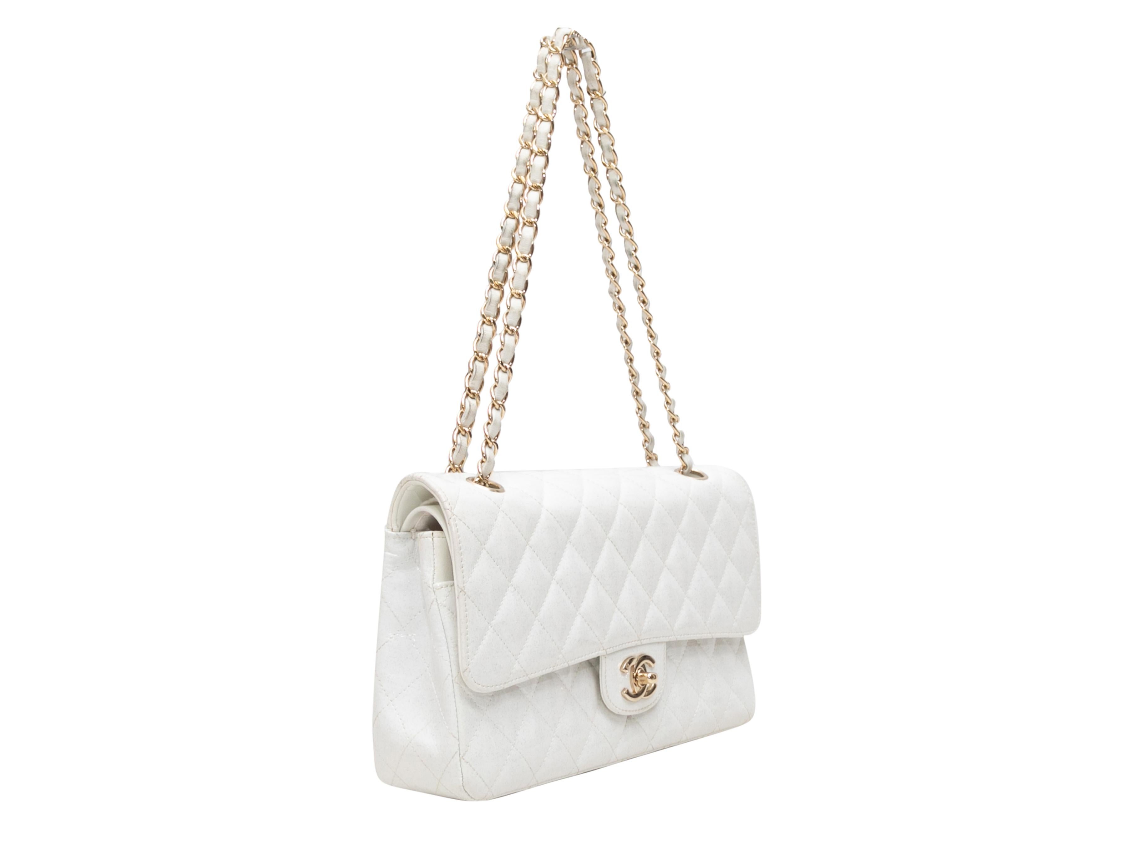 White Chanel Patent Glitter Medium Double Flap Bag. The Medium Double Flap Bag features a glitter patent leather body, gold-tone hardware, an exterior back pocket, dual chain-link shoulder straps, and a CC turn-lock closure at front flap. 10