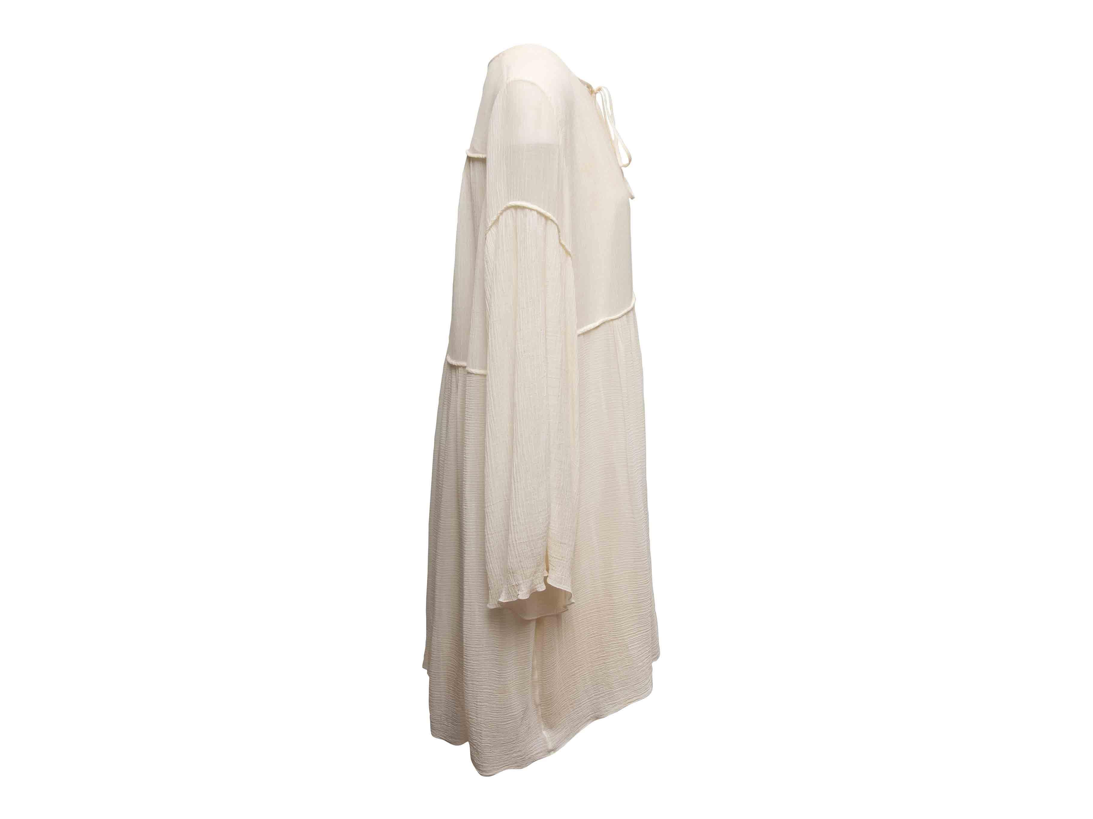 Robe ample à manches longues au genou en coton et soie blanche par Chloé. Encolure en V agrémentée d'un nœud de cravate. Poitrine 44