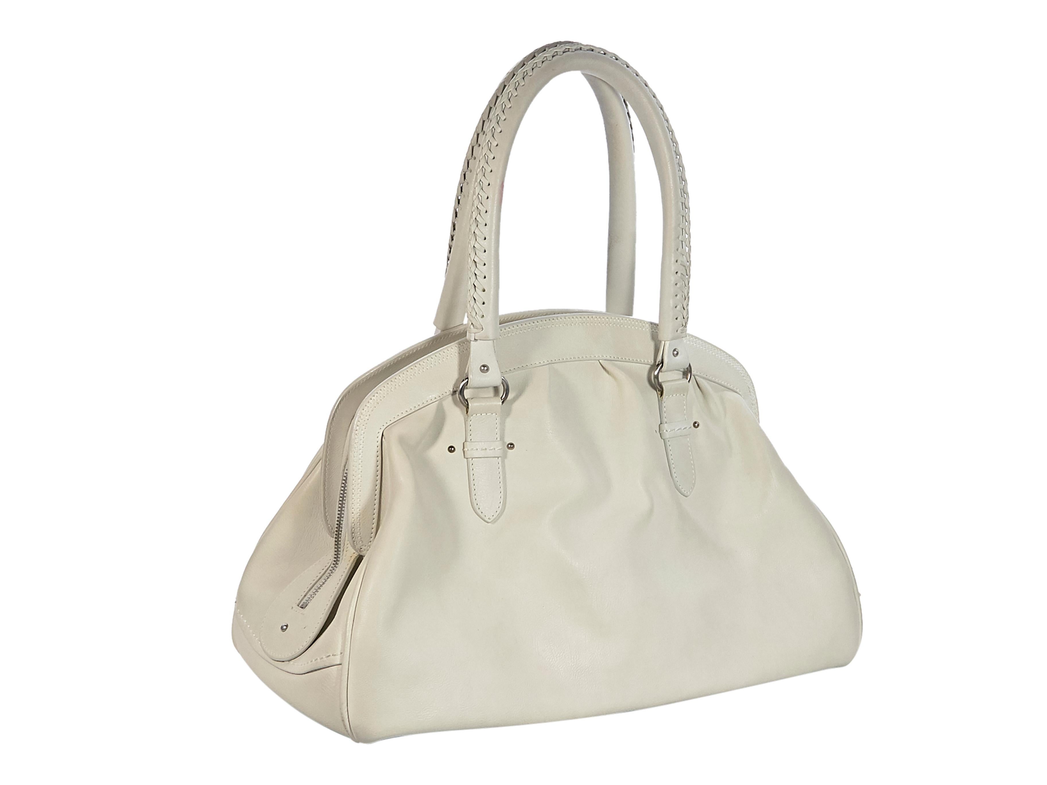 Product details:  White leather hobo bag by Christian Dior. Dual leather shoulder straps.  Zip top closure. Lined interior with inner zip pocket.  Two exterior flap pockets. Protective metal feet. Silver-tone hardware. 14.5