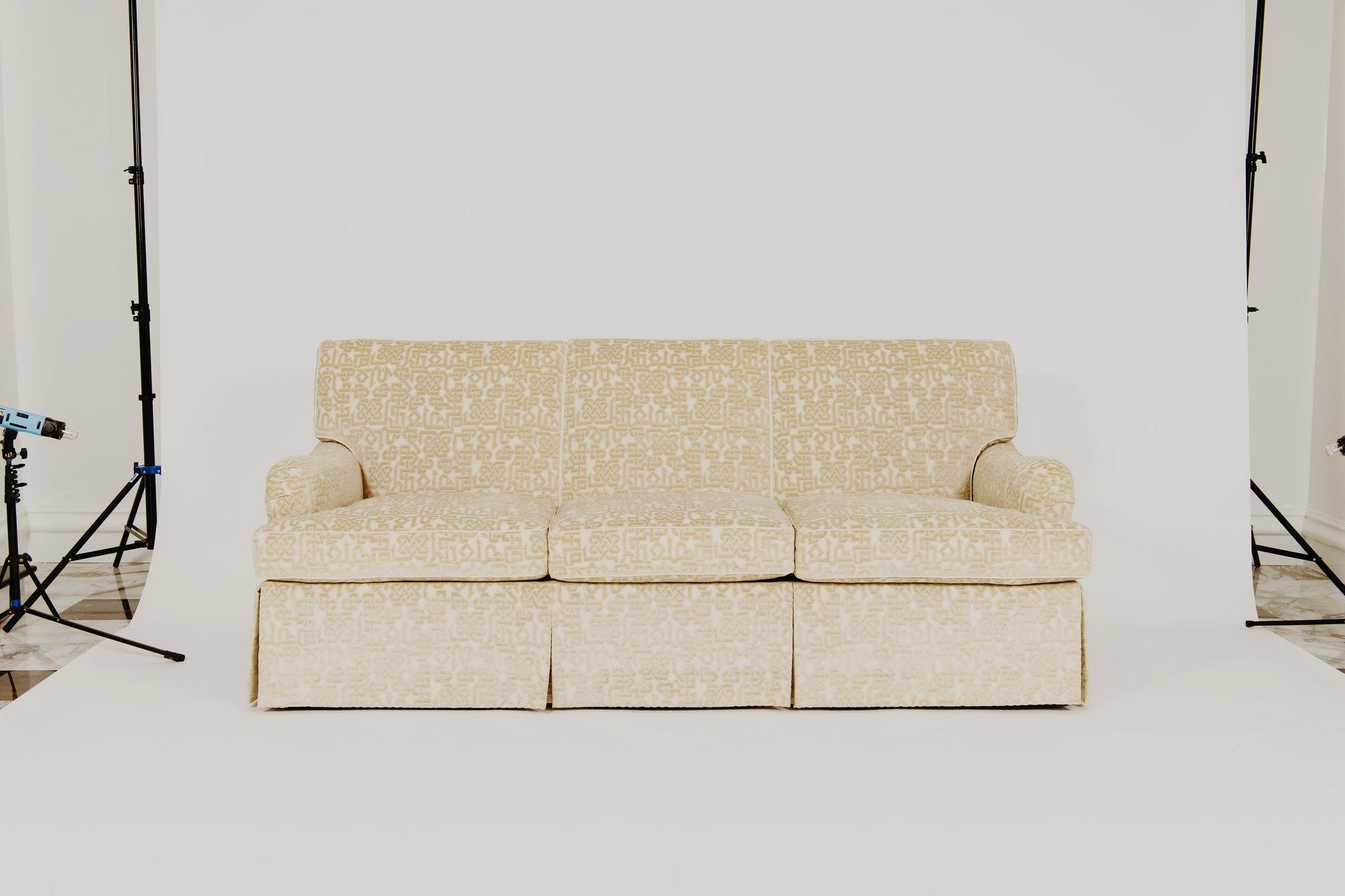A custom eight-way hand tied, kiln dried hardwood sofa with feather down wrapped spring coil cushions upholstered in Classic cloth white ecru cut linen velvet.