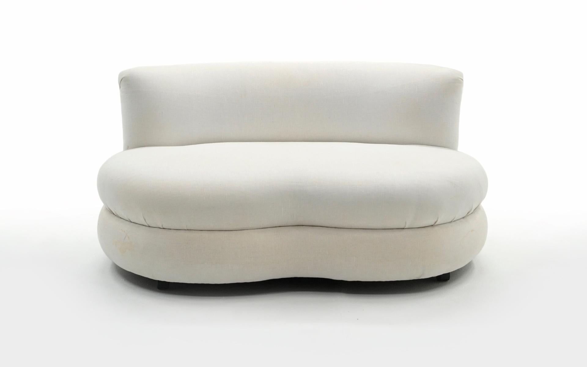 Cloud shaped settee / love seat / chair and a half in white upholstery. We are unsure of the designer but is similar to designs by Vladimir Kagan. Fixed cushion design. Foam is good. Fabric has areas of yellowing and light stains. It can be used as