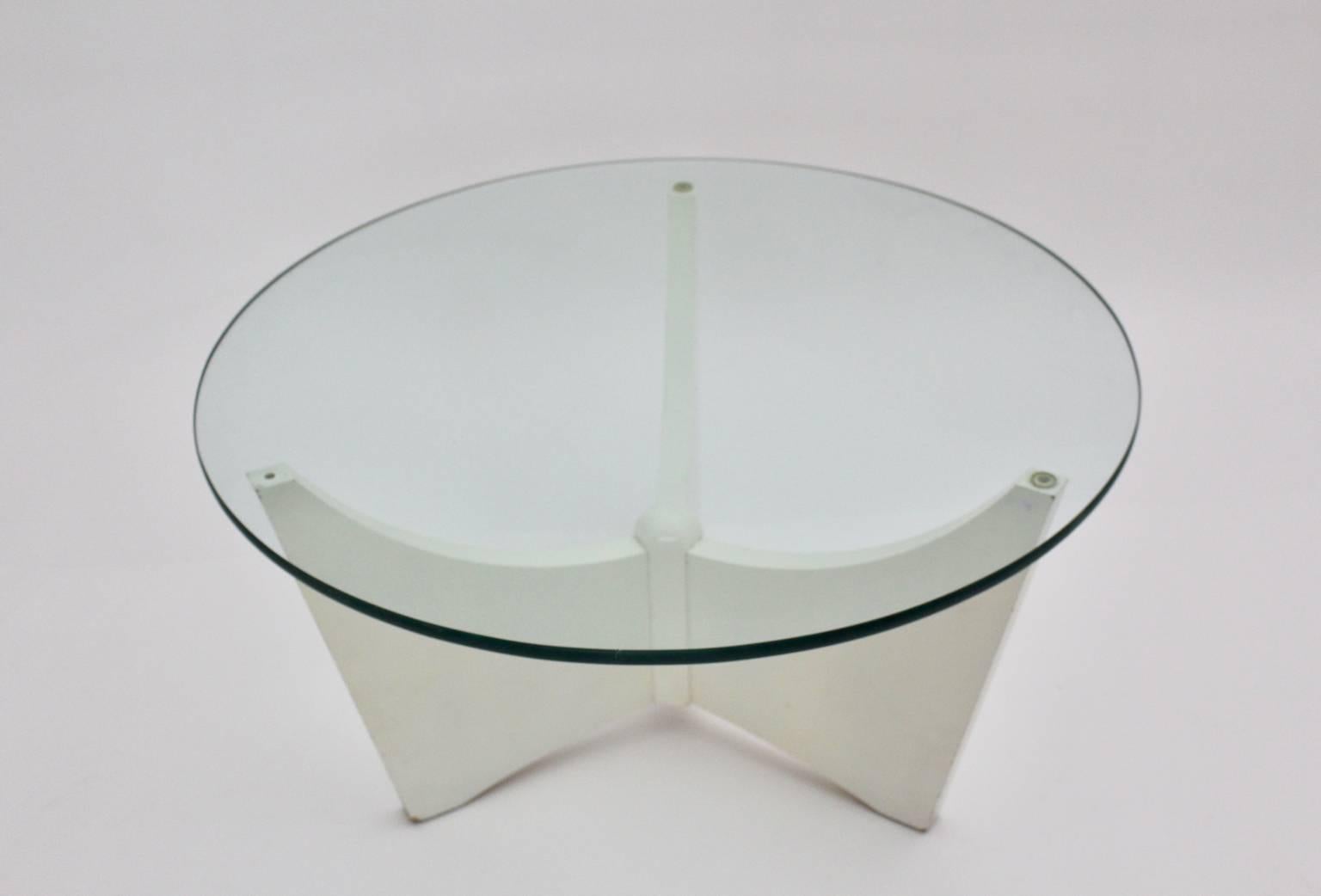 Table basse vintage de l'ère spatiale, qui présente des pieds en bois disposés en forme de trépied et peints en blanc, tout en tenant une assiette en verre dans un style typique des années 1970. Le plateau en verre a une épaisseur de 1,4 cm et