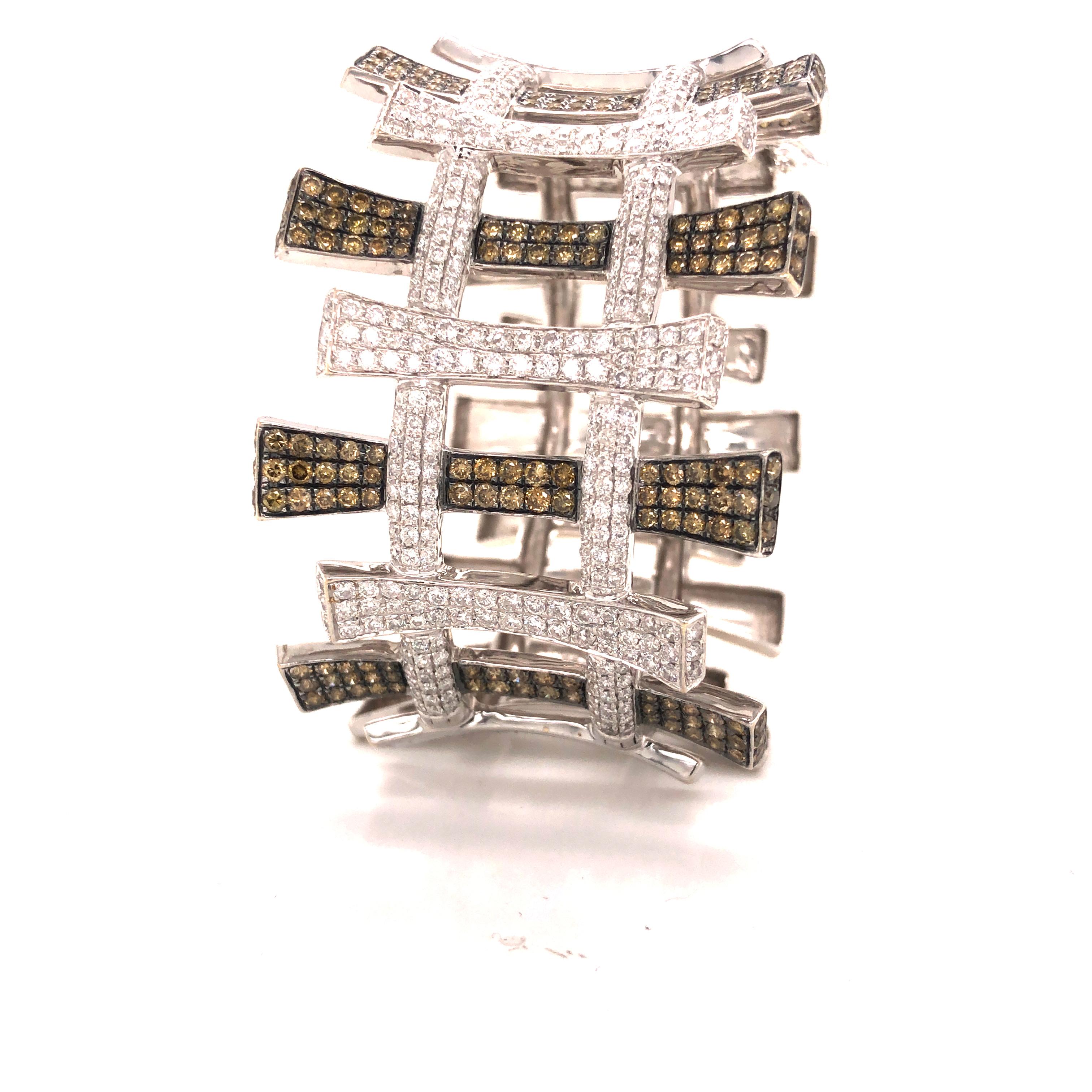 Amazing cuff bracelet crafted in 18k white gold.  This large design will surely fill up your wrist and be the talk of the night whenever worn. White and Cognac brown natural diamonds are set throughout the design. A total of 12.80 ct. are set into