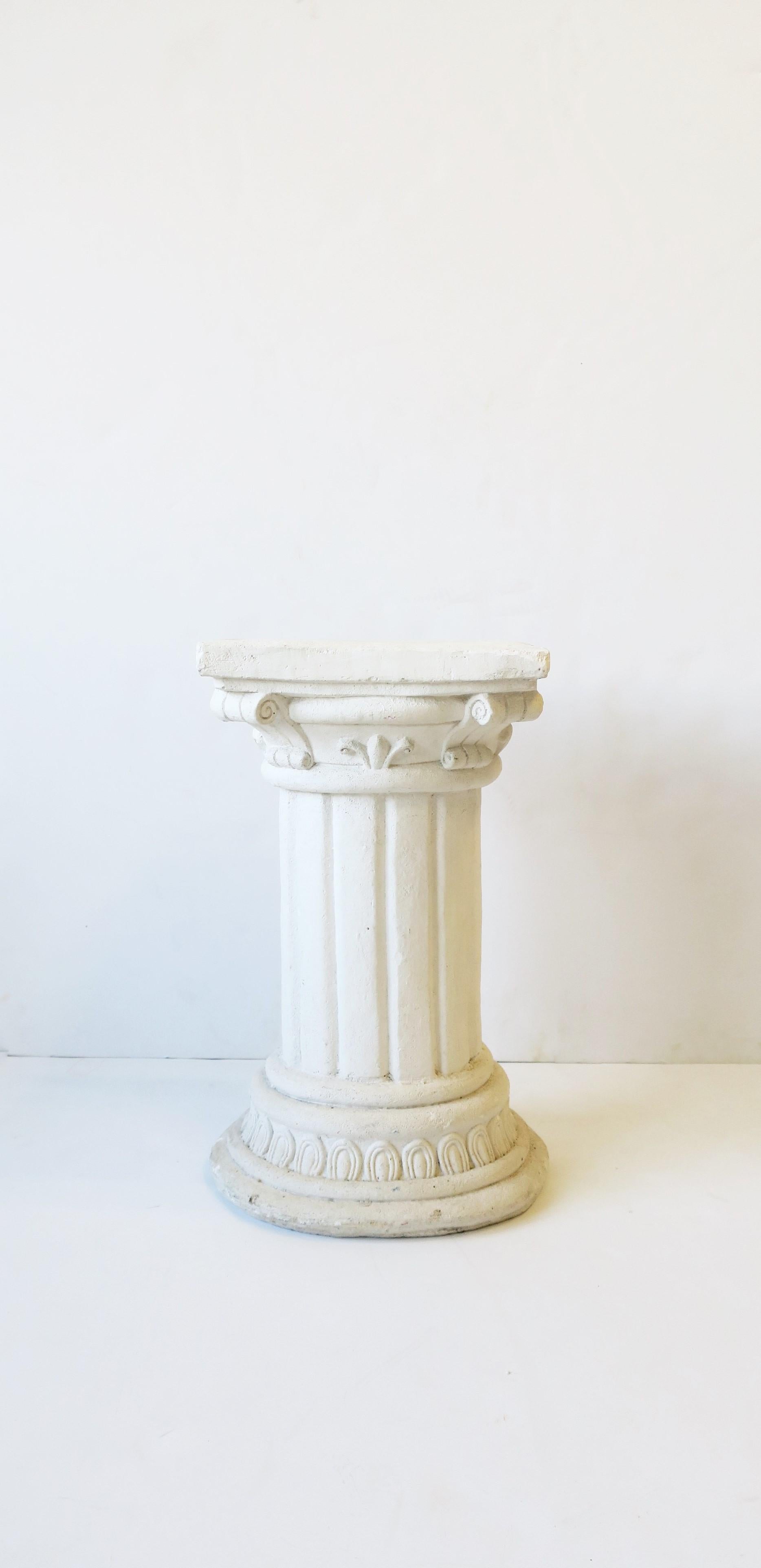 A white plaster and concrete Grecian Ionic style column pillar pedestal side or drinks table, circa mid-20th century. Piece can work as a pedestal side/drinks table or as a pedestal stand for sculpture, plant, etc. 

Dimensions include: 
9