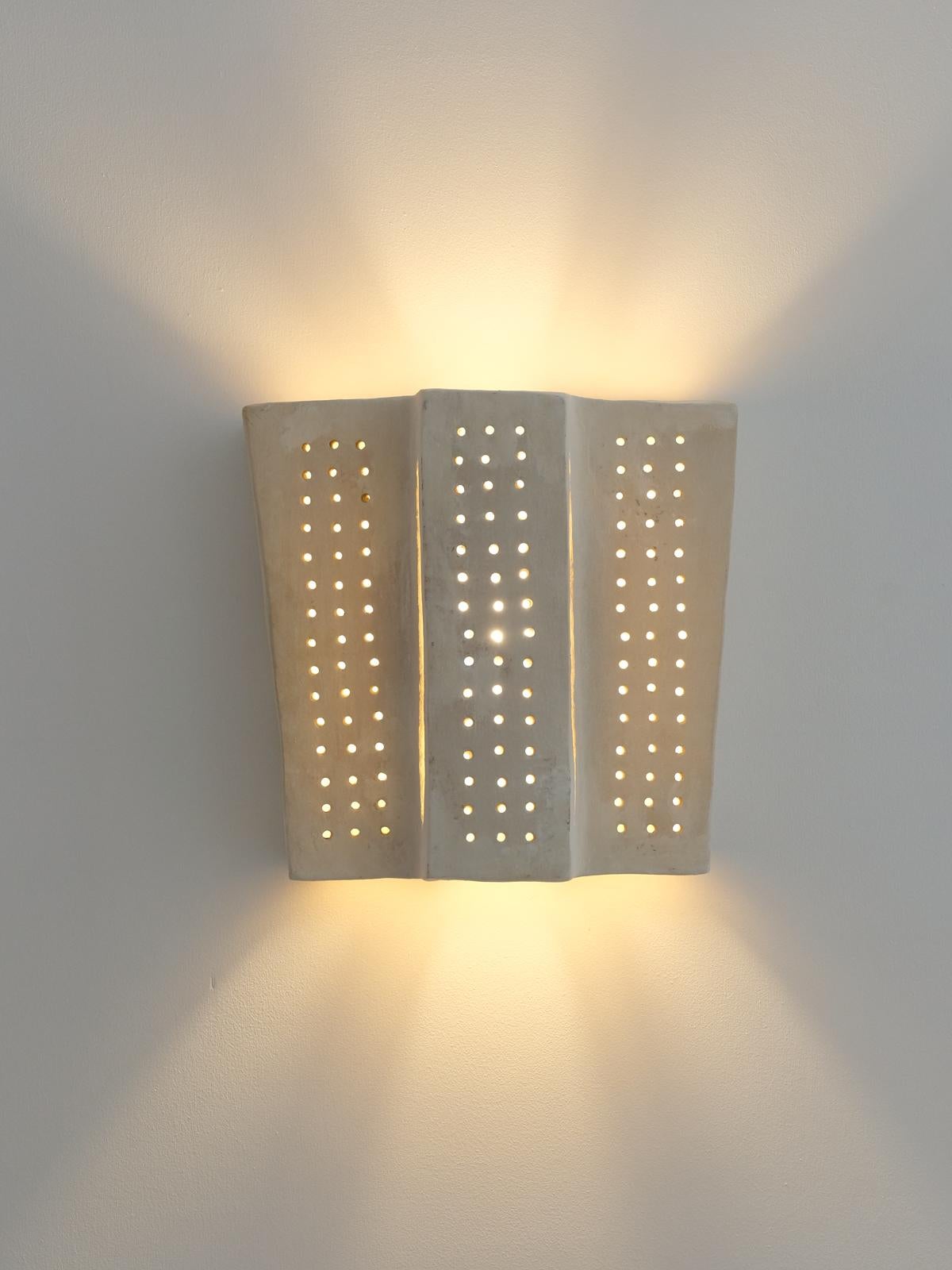 - Handbuilt white ceramic wall light
- made of clay collected from the potter's surroundings.
- made in the Moroccan Rif mountains by the potter Houda.
- co-created by the potter Houda x memòri team
- small scale-production
- an extra fixing is
