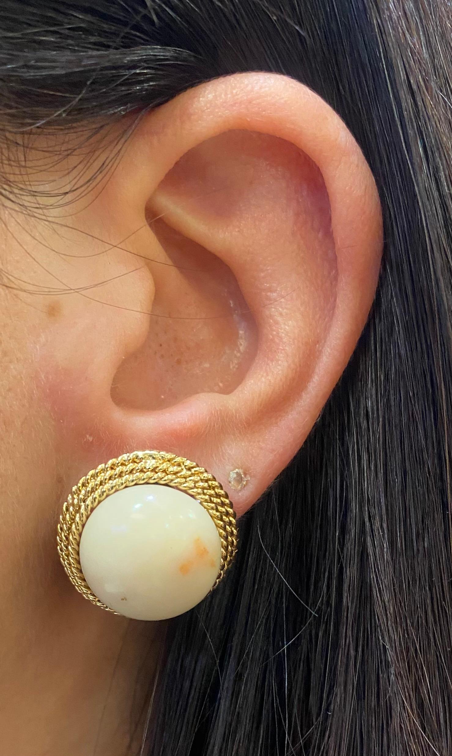 Orecchini di corallo bianco cabochon. 

Un paio di orecchini con due coralli bianchi cabochon e un motivo a corda in oro.

Misure: 0,75