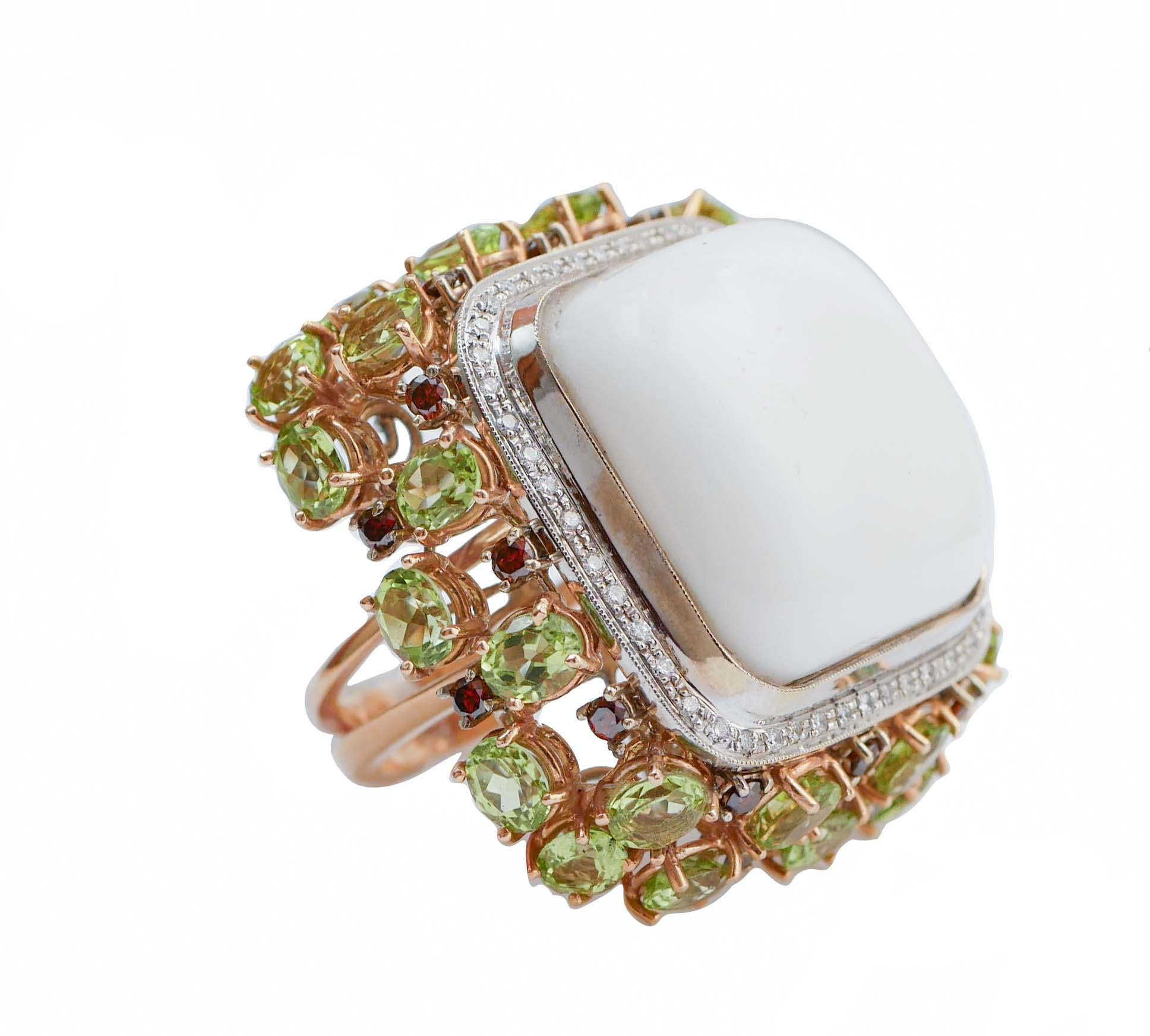 Anillo retrò de moda en estructura de oro rosa de 18 kt montado con un coral blanco central rodeado por un marco de oro blanco tachonado de diamantes.  Alrededor, peridotos y granates.
Este anillo fue totalmente hecho a mano por maestros orfebres