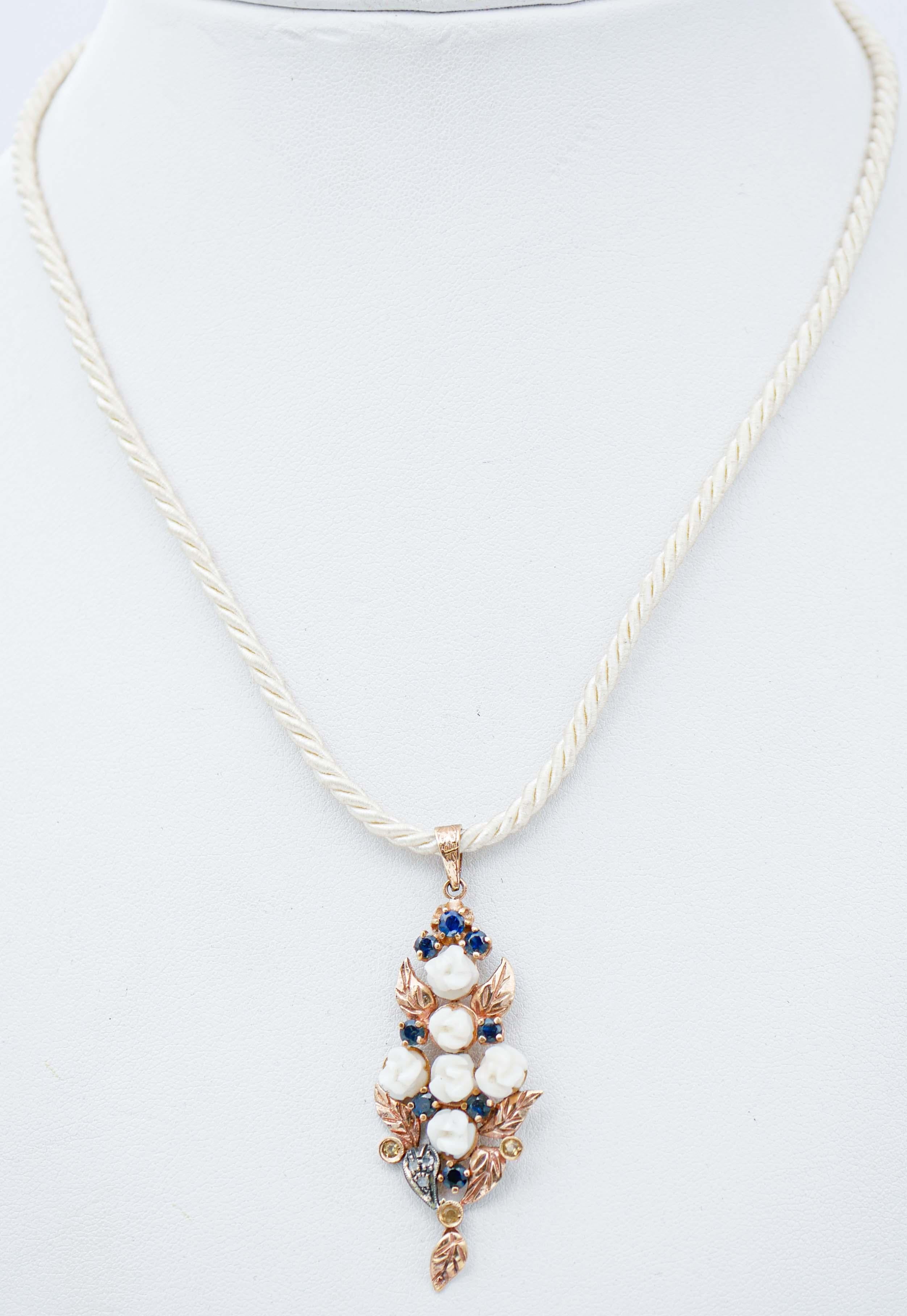 Beautiful retrò pendant in 9 karat rose gold and silver structure mounted with flowers of white coral between blue and yellow sapphires and diamonds.
This pendant was totally handmade by Italian master goldsmiths and it is in perfect