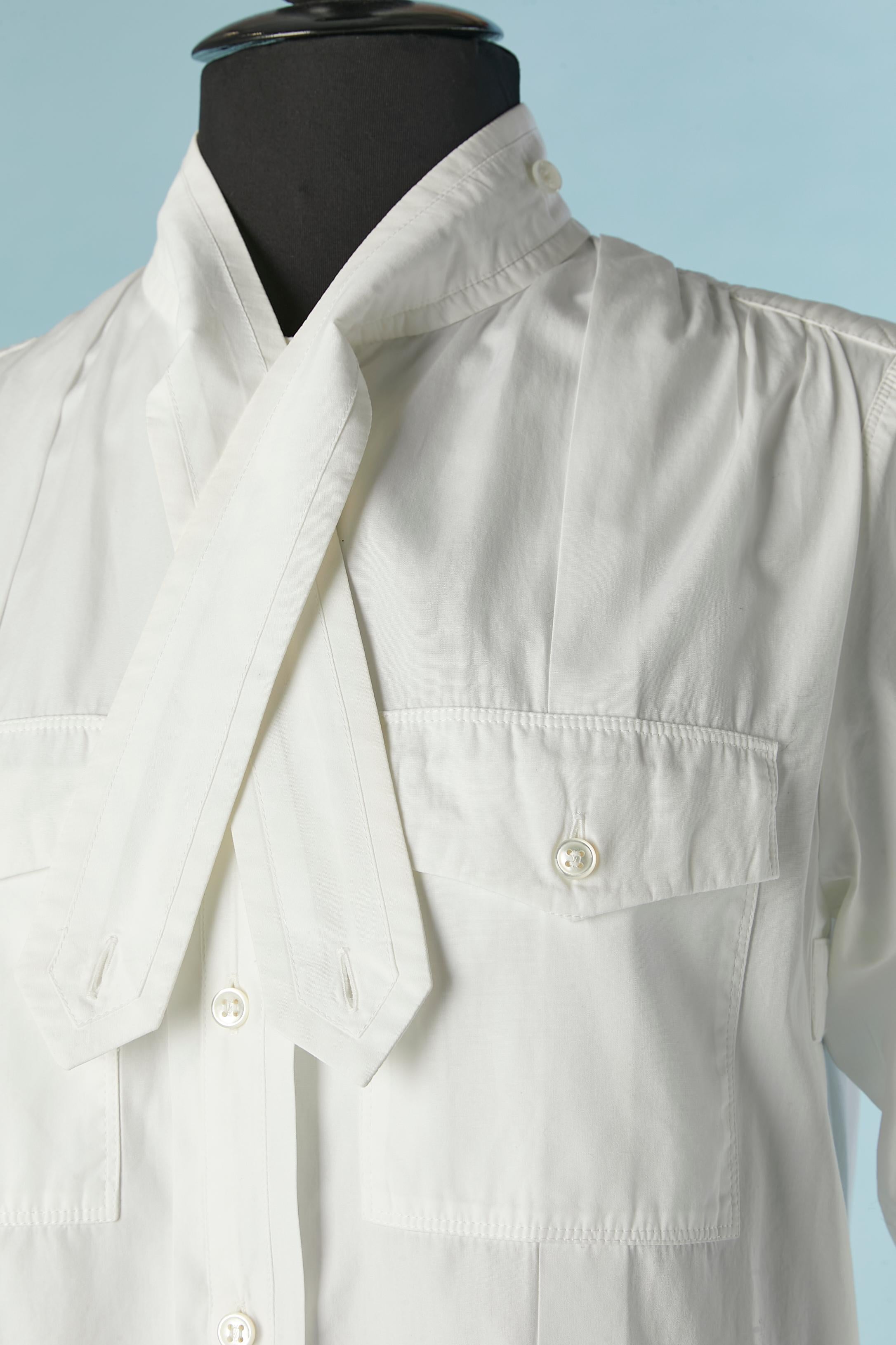 Robe nuisette en coton blanc avec fermeture par boutons et boutonnières sur le milieu du devant, sur le rabat de la poche, sur les poignets et sur le col. 
TAILLE 38 (Fr) M 