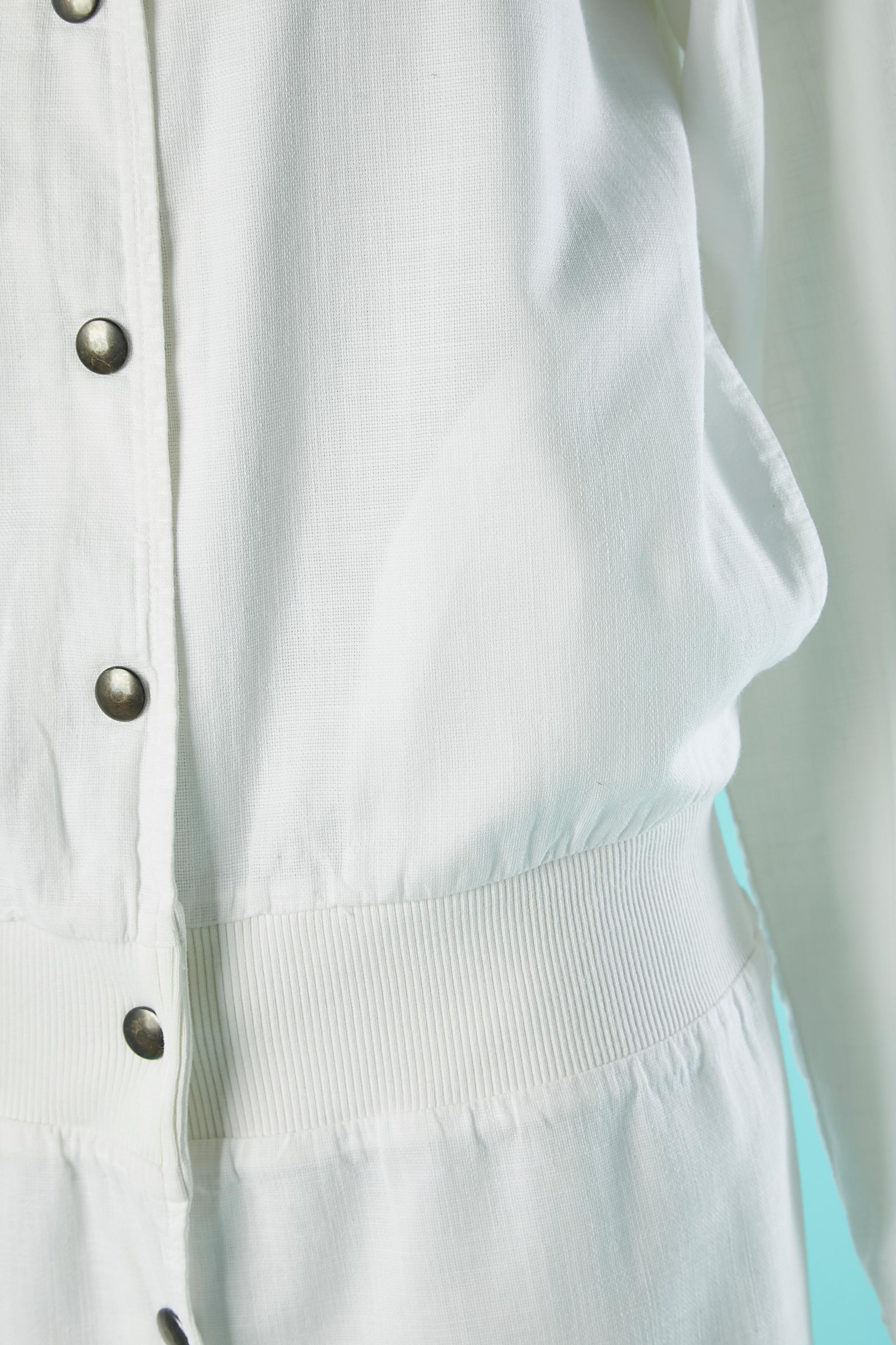 Manteau en coton blanc avec capuche et fermeture à boutons-pression. Il n'y a pas d'étiquette mais le tissu principal est en coton, peut être mélangé avec du lin et la doublure est 100% coton. Pochette sur les deux côtés.
Cette pièce provient de la