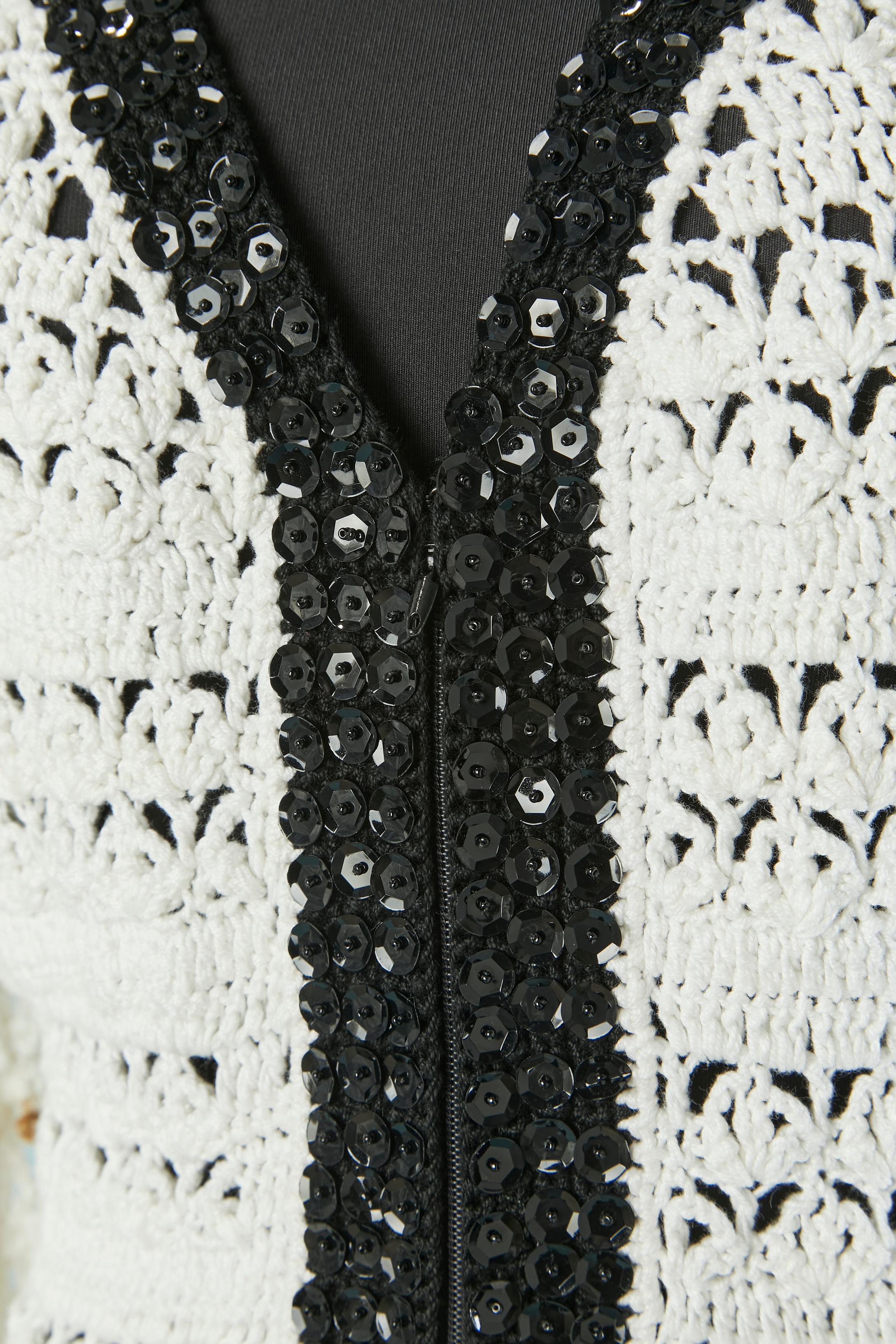 Robe en crochet de coton blanc avec bordure de paillettes noires sur une base de crochet noir. Fermeture à glissière et crochet sur le milieu supérieur du devant. 
TAILLE M 
