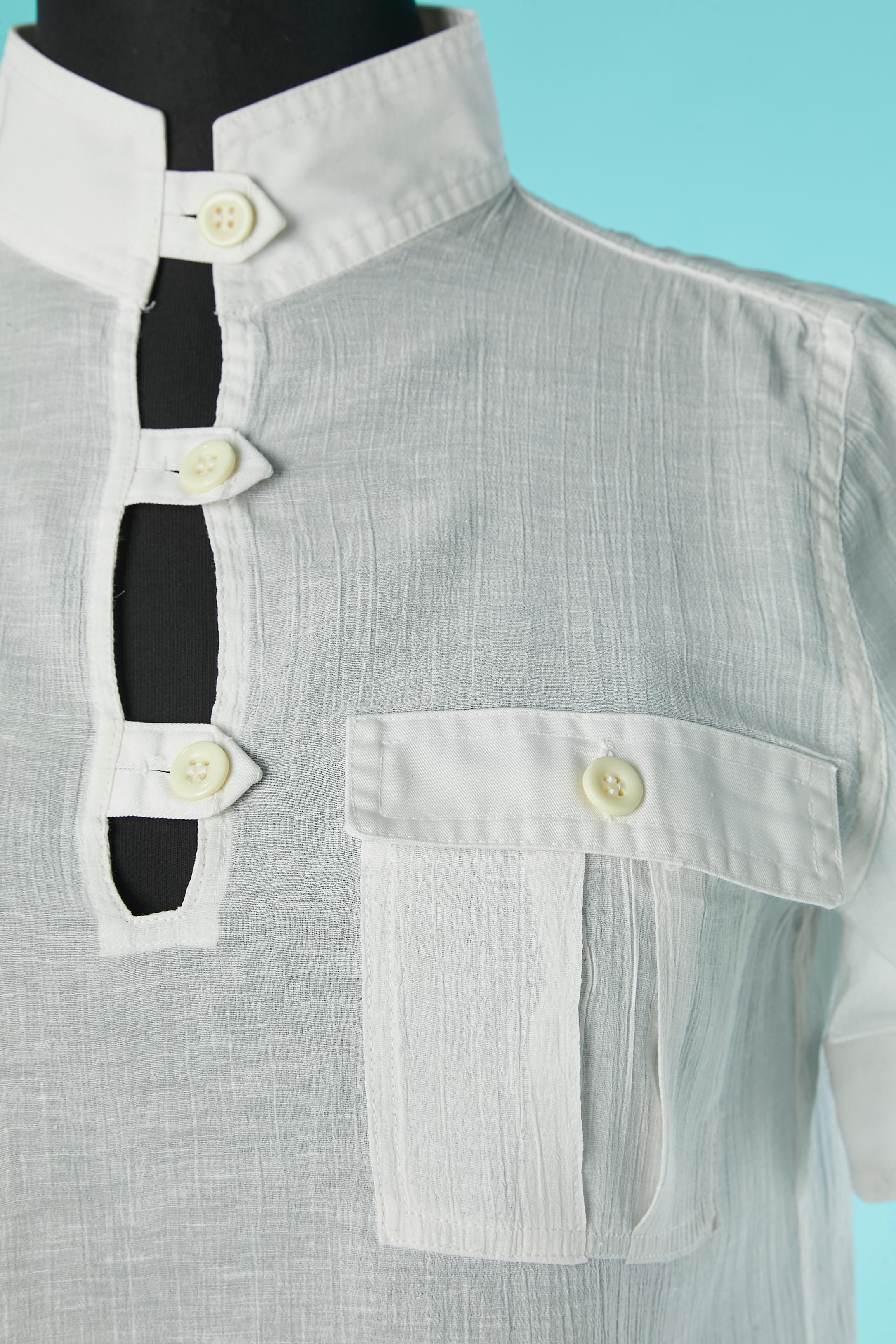 White cotton shirt with short sleeve .Button & buttonhole in the front, pockets and back. 
Box-pleat in the middle back. 2 differents type of cotton between the pockets flap/collar/sleeve edge and the main fabric
SIZE 