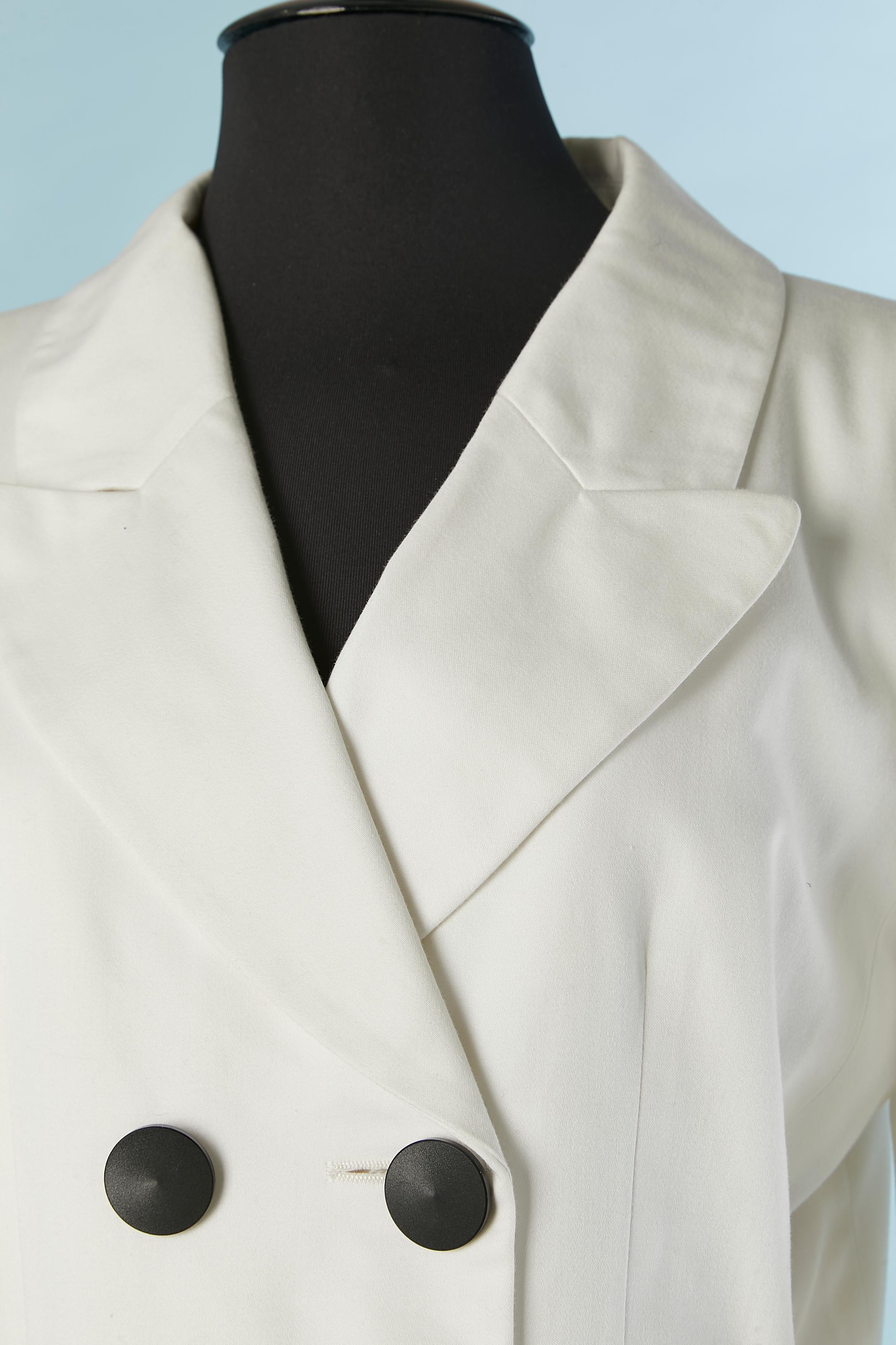 Tailleur jupe en coton blanc avec boutons noirs. Pas de composition de l'étiquette du tissu mais la doublure est probablement en acétate ou en rayonne. Pad d'épaule. 
Taille 36 (Fr) pour la veste mais convient à M/L et 38 (Fr) pour la jupe mais