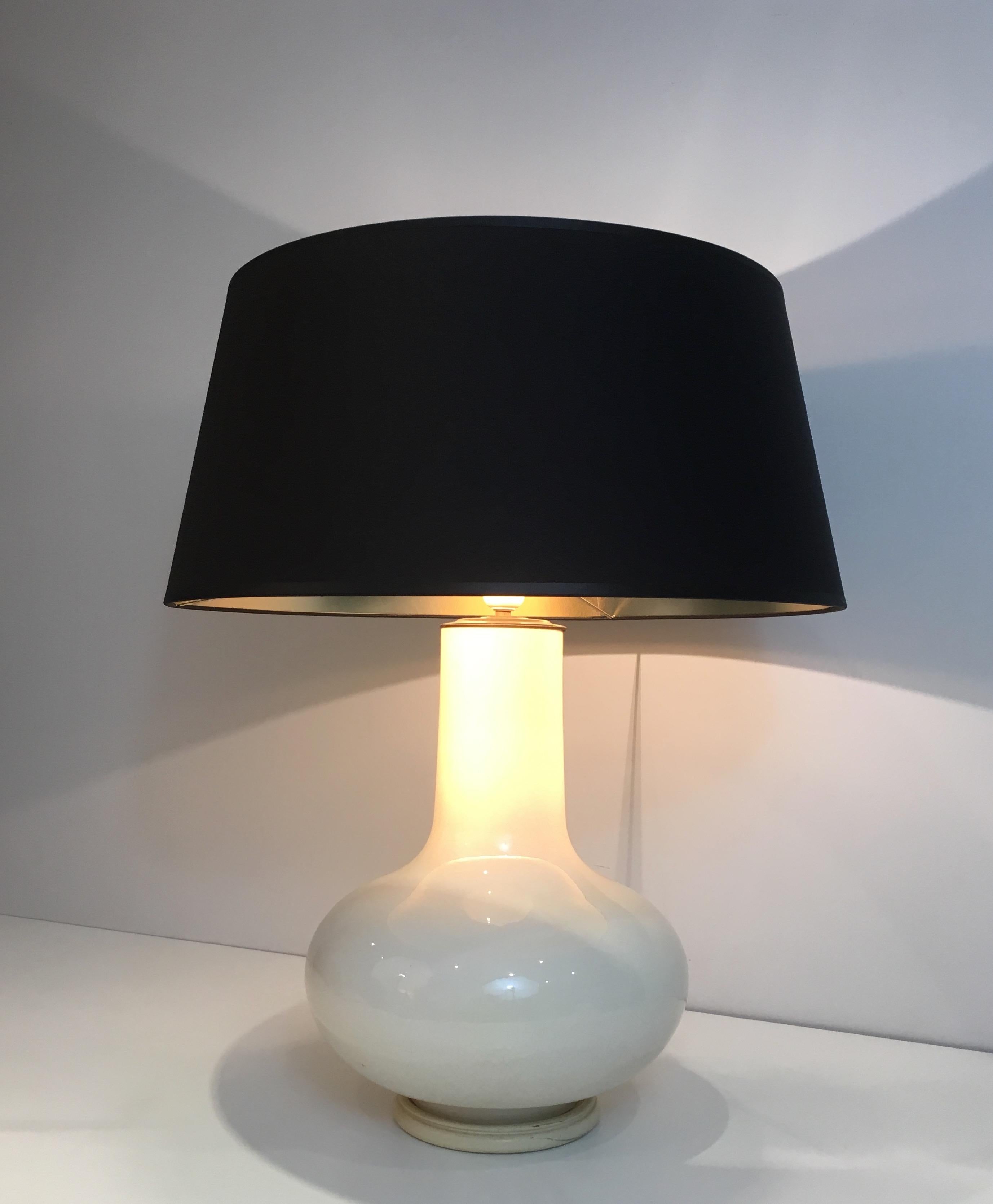 This table lamp is made of white crackled ceramic with a black shade gilt inside. This is a French work, circa 1970.