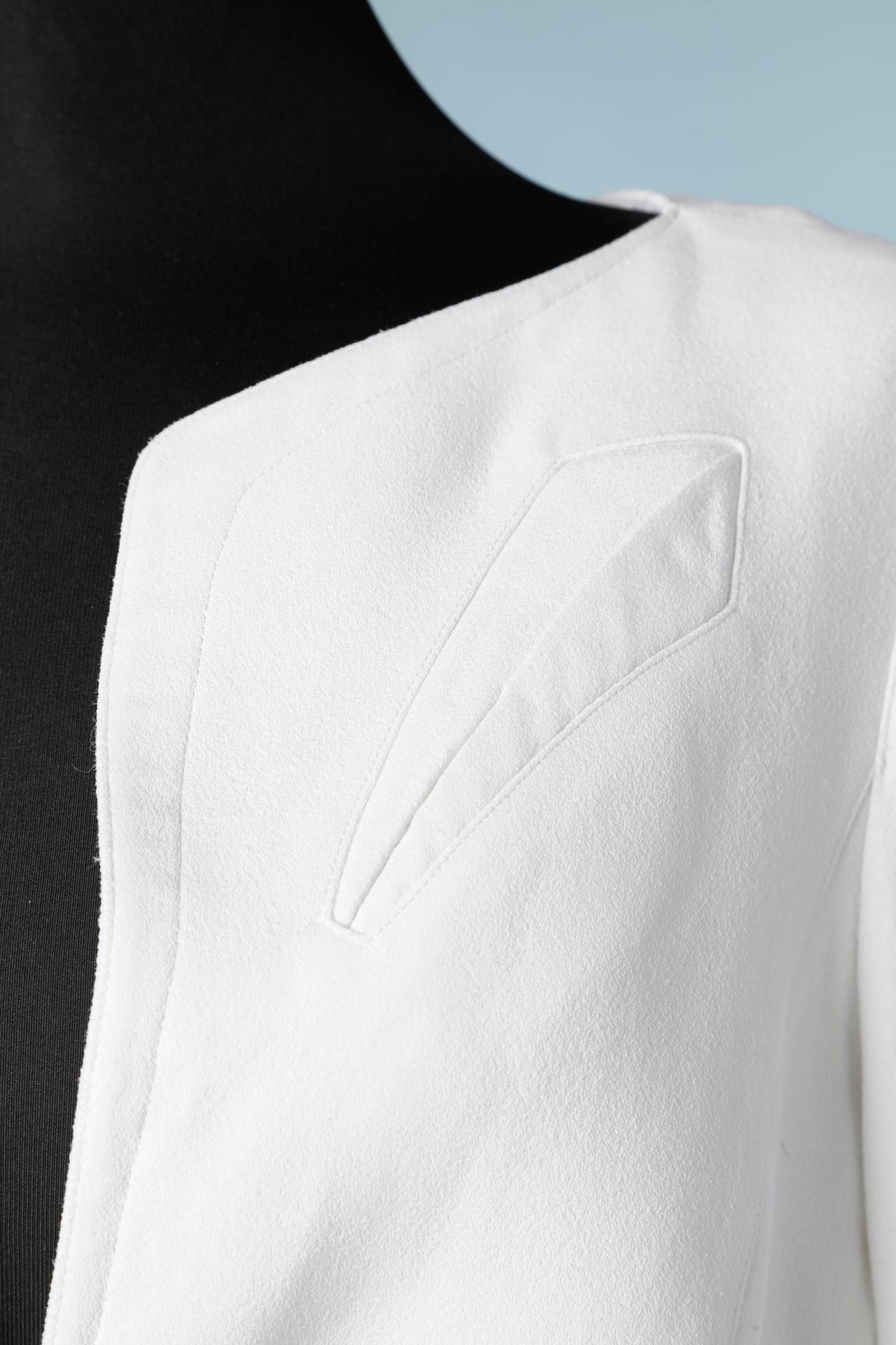 Combinaison jupe en crêpe blanc. Jupe portefeuille, veste simple.
L'étiquette de la marque a été coupée. 