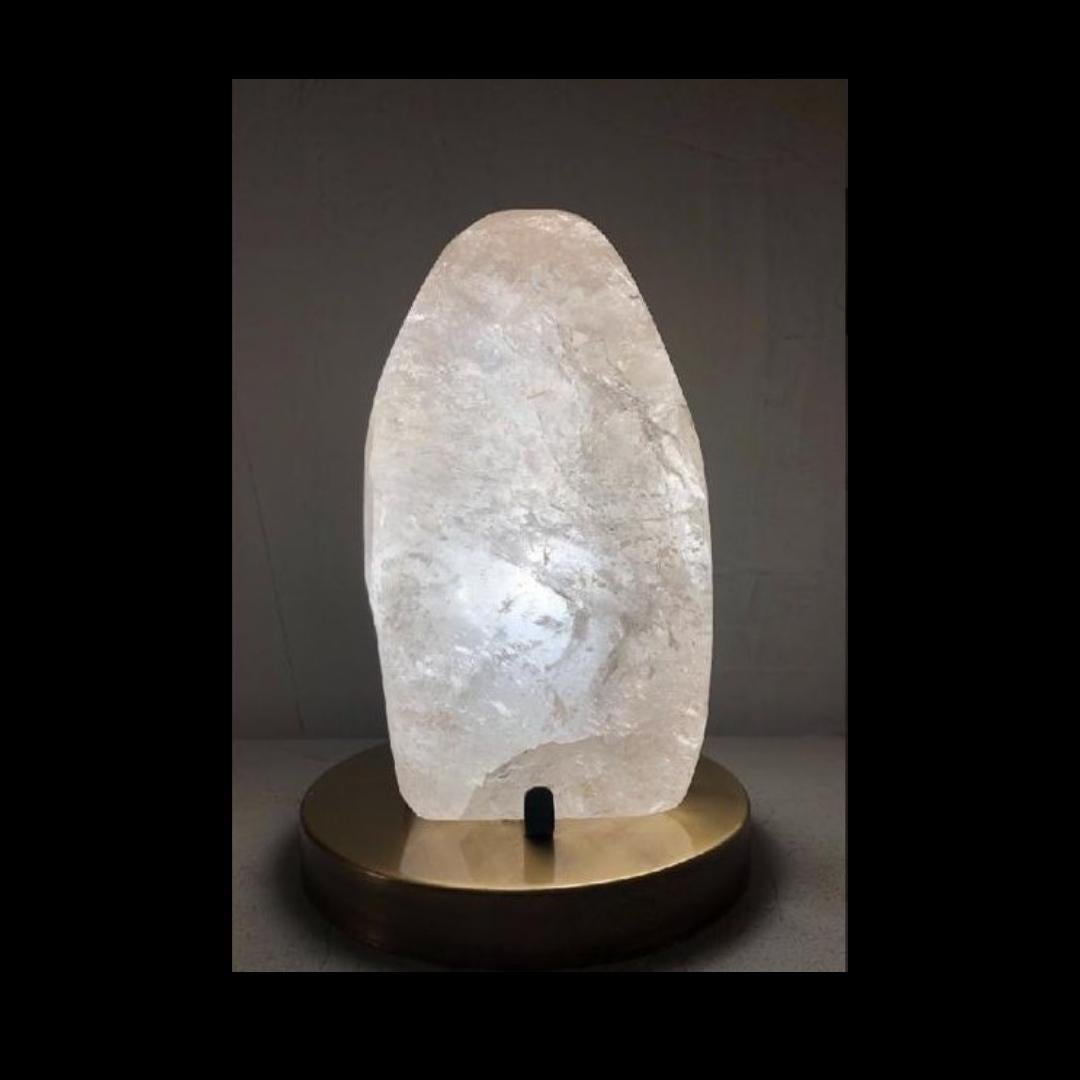Beautiful table lamp created with polished crystal rock. Inside, the piece is lit by a led light , creating a gorgeous atmosphere lighting .
The elegant base is refitted in iron, finish of rusted brass. 

The process of creation goes through