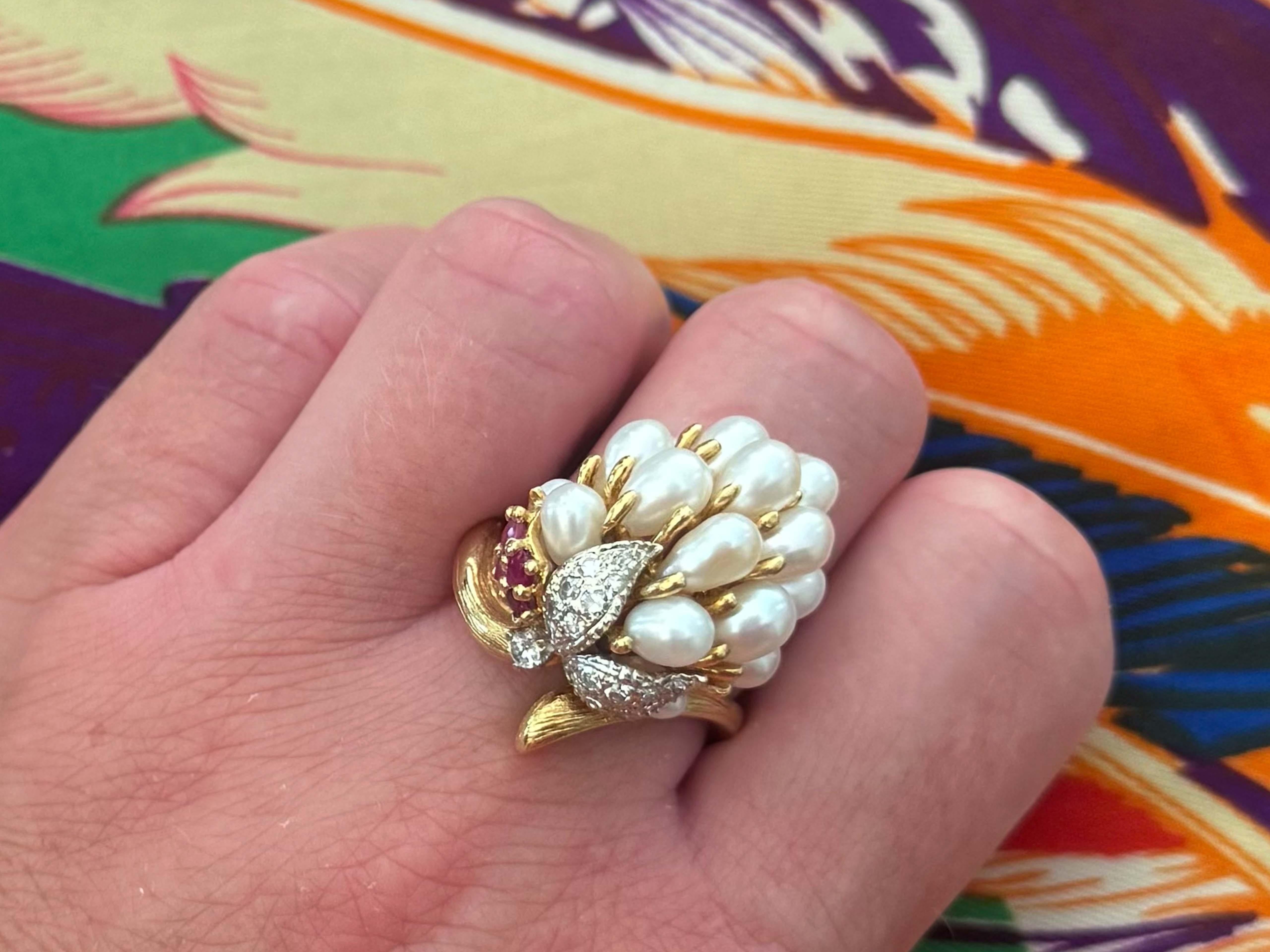 Ring Specifications:

Metal: 18k Yellow Gold

Total Weight: 18.3 Grams

Pearl Diameter: ~5.3 mm - ~6.5 mm

Pearl Count: 19 white cultured pearls
​
​Ruby Count: 4 round rubies
​
​Ruby Diameter: ~2.4 mm
​
​Ruby Carat Weight: ~0.20 carats

Diamond