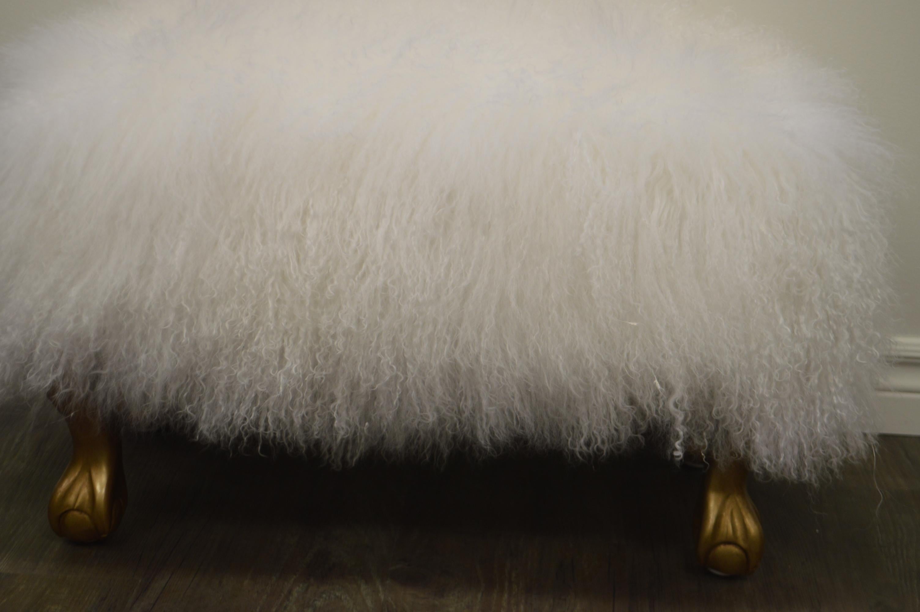 Custom made ottoman with a curly white lambswool skin, very charming and fluffy on four gilded legs.