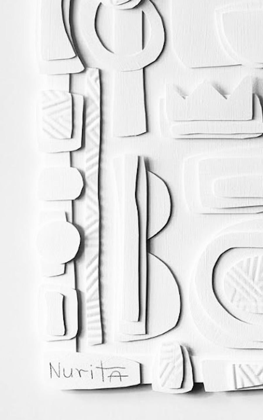 Collage de recortes de papel blanco sobre blanco.
Marco de madera blanca.
La artista Nurit Amdur crea recortes de papel y collages que giran en torno al viaje de transición y a convertir algo en 