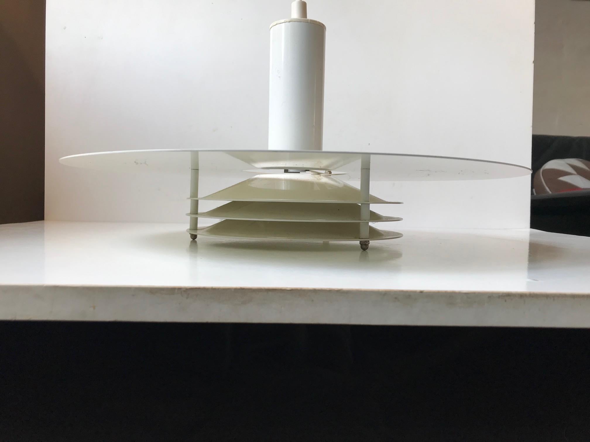 Large ceiling light with tiered white enameled steel shades. It is designed by Knud Christensen in Denmark during the 1970s. Its features its original porcelain fitting.