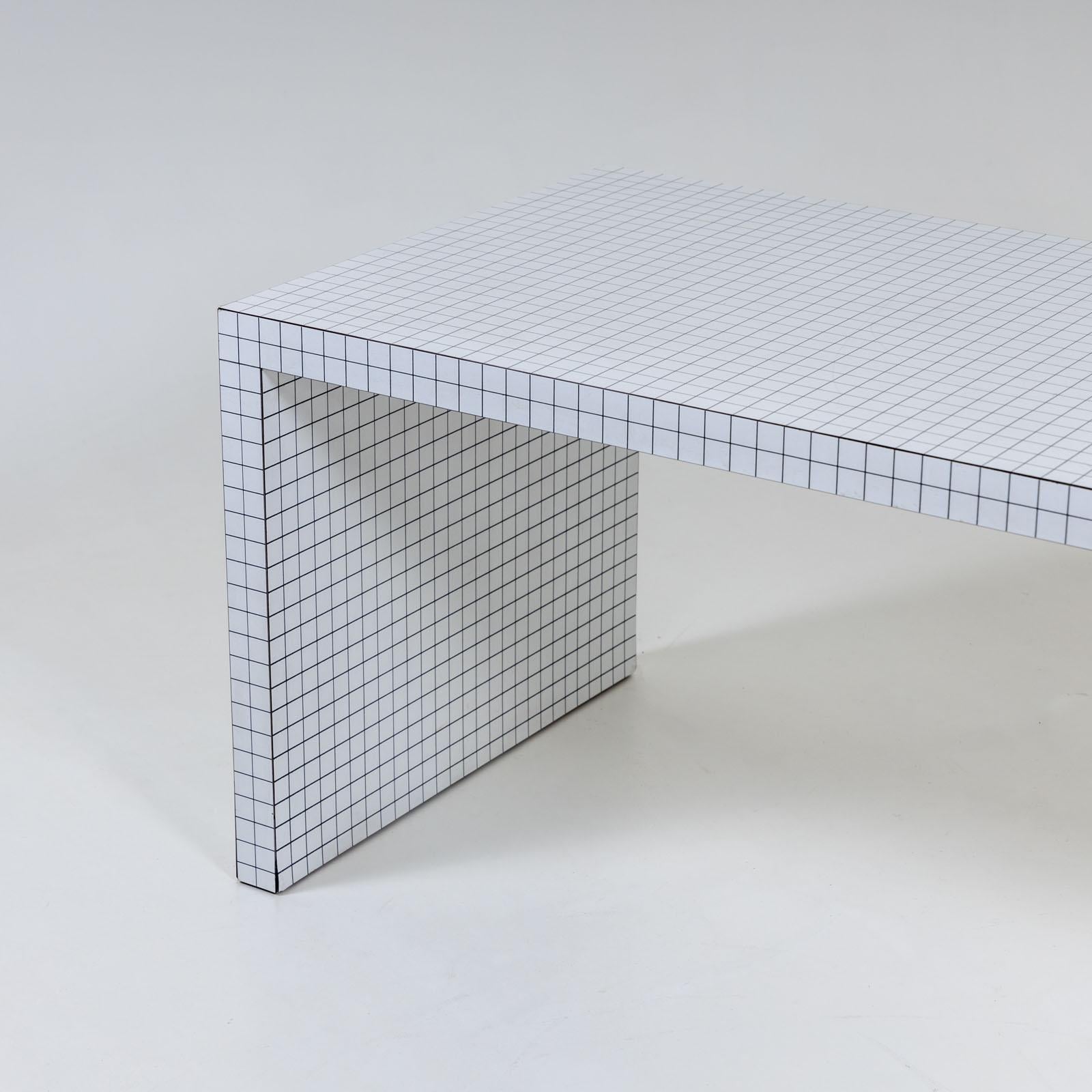 Schreibtisch mit laminierter weißer Oberfläche mit Karomuster. Die Linien haben einen Abstand von 3 cm und gehen an den Rändern und glatten Seiten nahtlos ineinander über. Der Digitaldruck wurde sorgfältig auf eine durchgehend laminierte Oberfläche