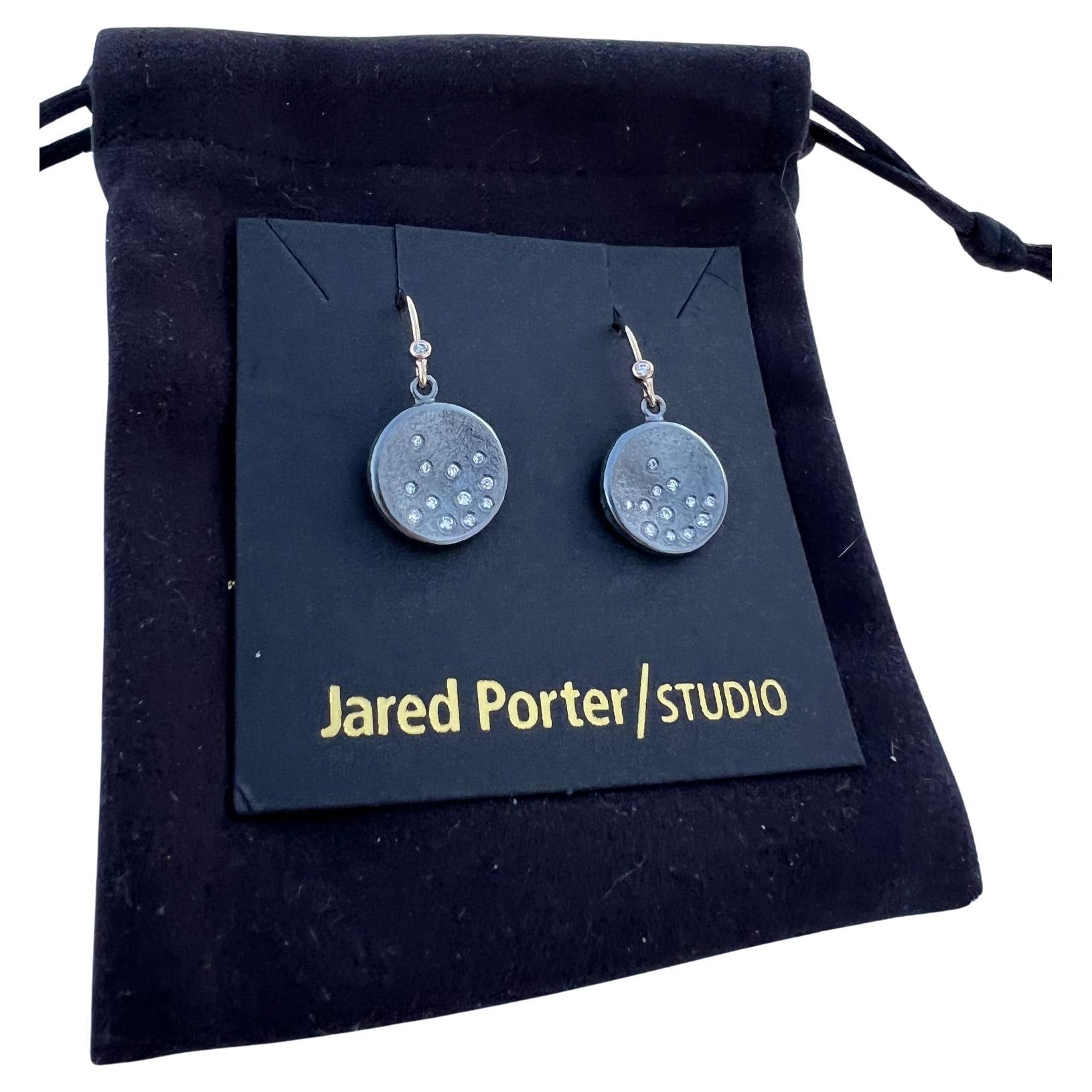 Beautiful earrings hand fabricated by Jared Porter Studio.

The inspiration behind this every day wearing earring was to give the feeling of snowfall or a bright starry nights sky.  

The disc is sterling silver with a dark patina (oxidized) finish