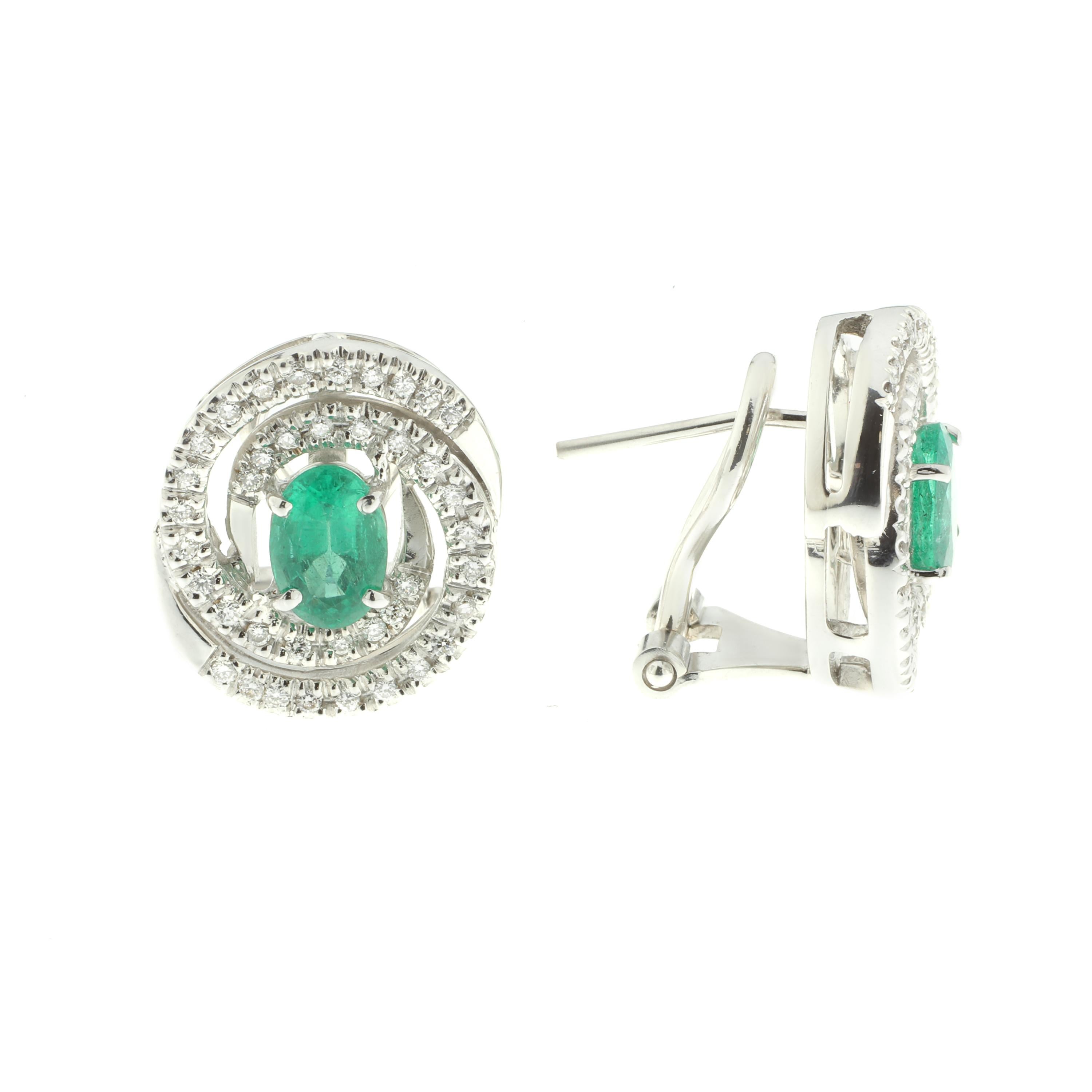 These earrings, featuring a stunning 1.36 carats of emeralds with beautiful white diamonds are masterfully handmade from 18-karat white gold. They have been worked with intricate precision into a beautiful stylized spiral that is certain to catch