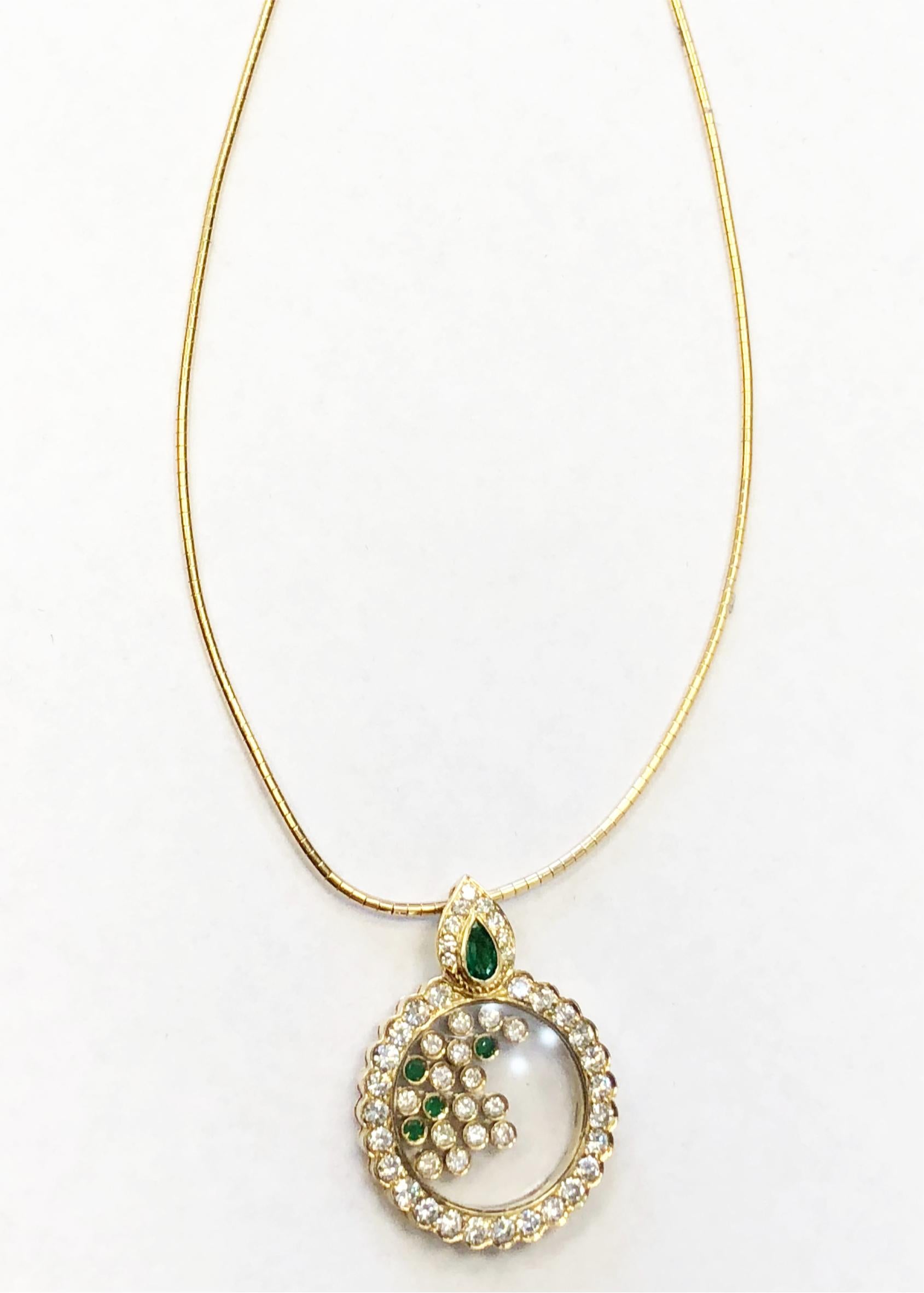 This gorgeous necklace showcases 0.60 carats of deep green emerald rounds and pear shape and 2.16 carats of white diamond rounds.  The free movement of the bezeled stones inside of a round diamond encasing makes this piece whimsical and fun.  The