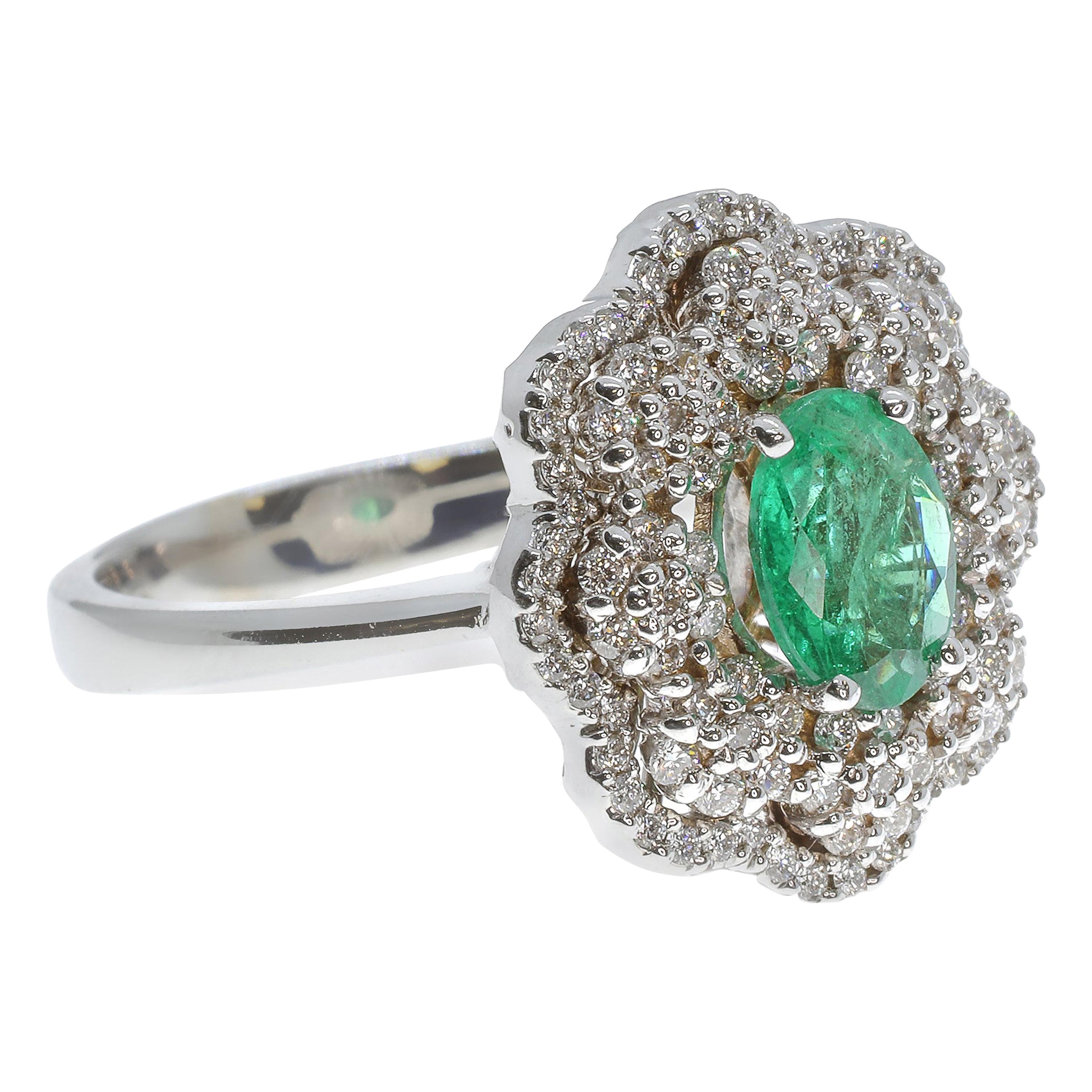 This dazzling jewel is hand-crafted in Sicily. The central emerald (.91 carats) is an incredible centrepiece, framed by clusters of .61 carats of sparkling white diamonds and set in 18-karat white gold. The ring is a unique beauty reminiscent of a