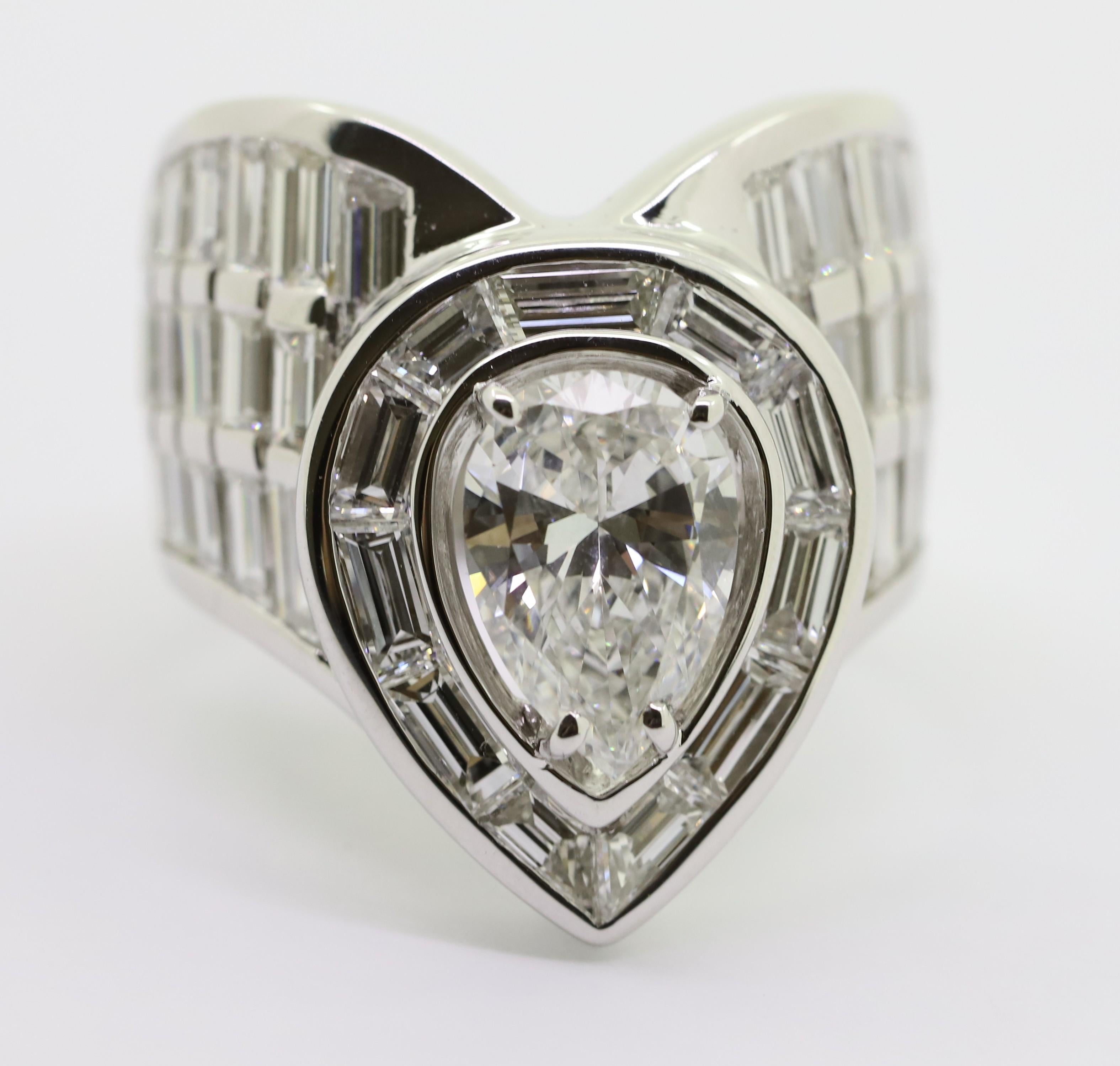 A large 18kt white gold ring with a drop-cut diamond in the center and baguette-cut diamonds.

The object remembers the shape of a heart, when we look at the drop on the reverse side.

Object made in Italy