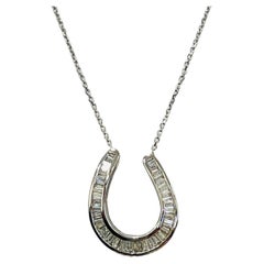 Collier à pendentif fer à cheval en or blanc 18 carats et diamants baguettes blancs