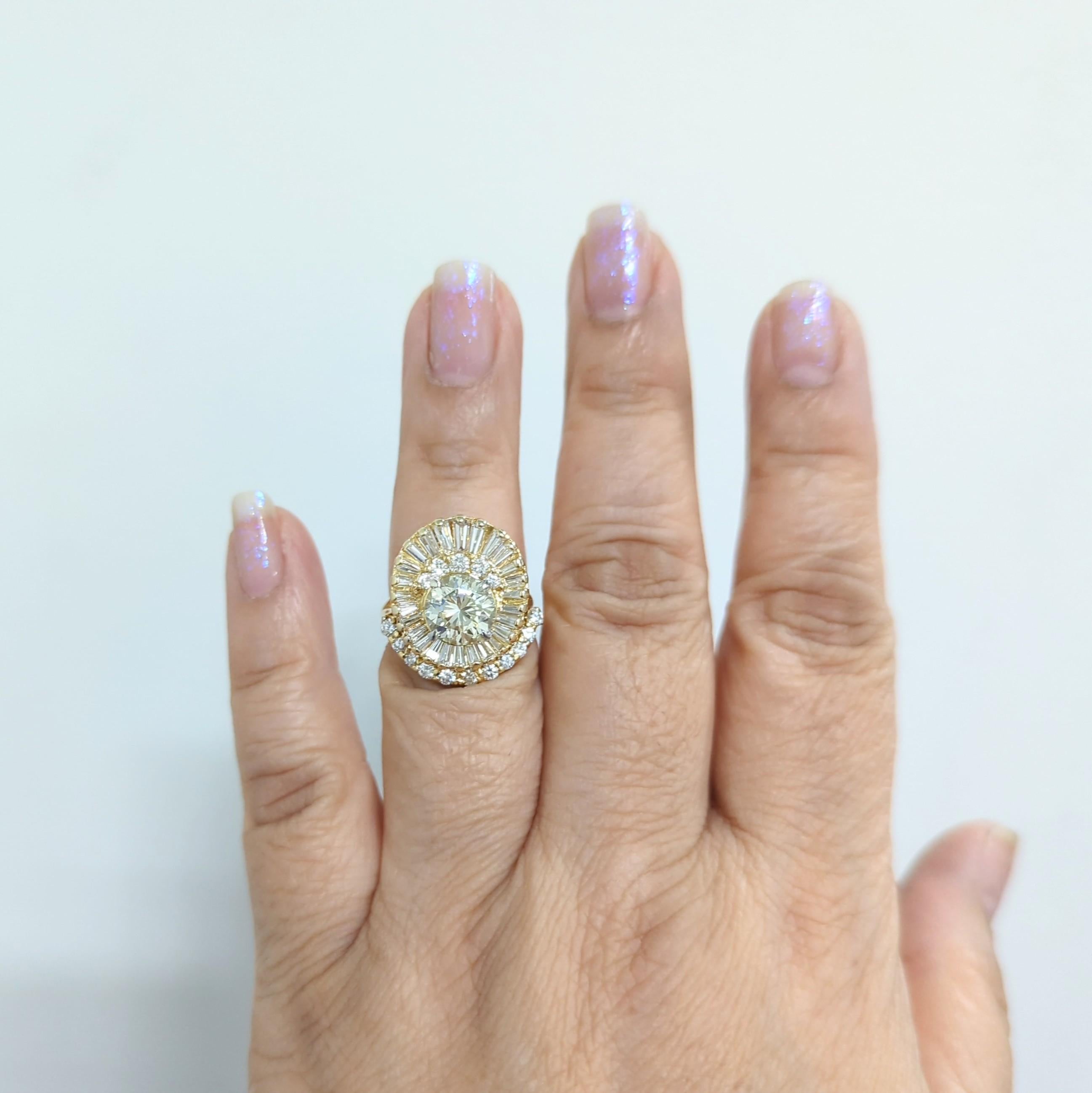 Beautiful 2.16 ct. white diamond round center with 1.20 ct. good quality white diamond baguettes and rounds surrounding the main stone.  Handmade in 18k yellow gold.  Ring size 7.