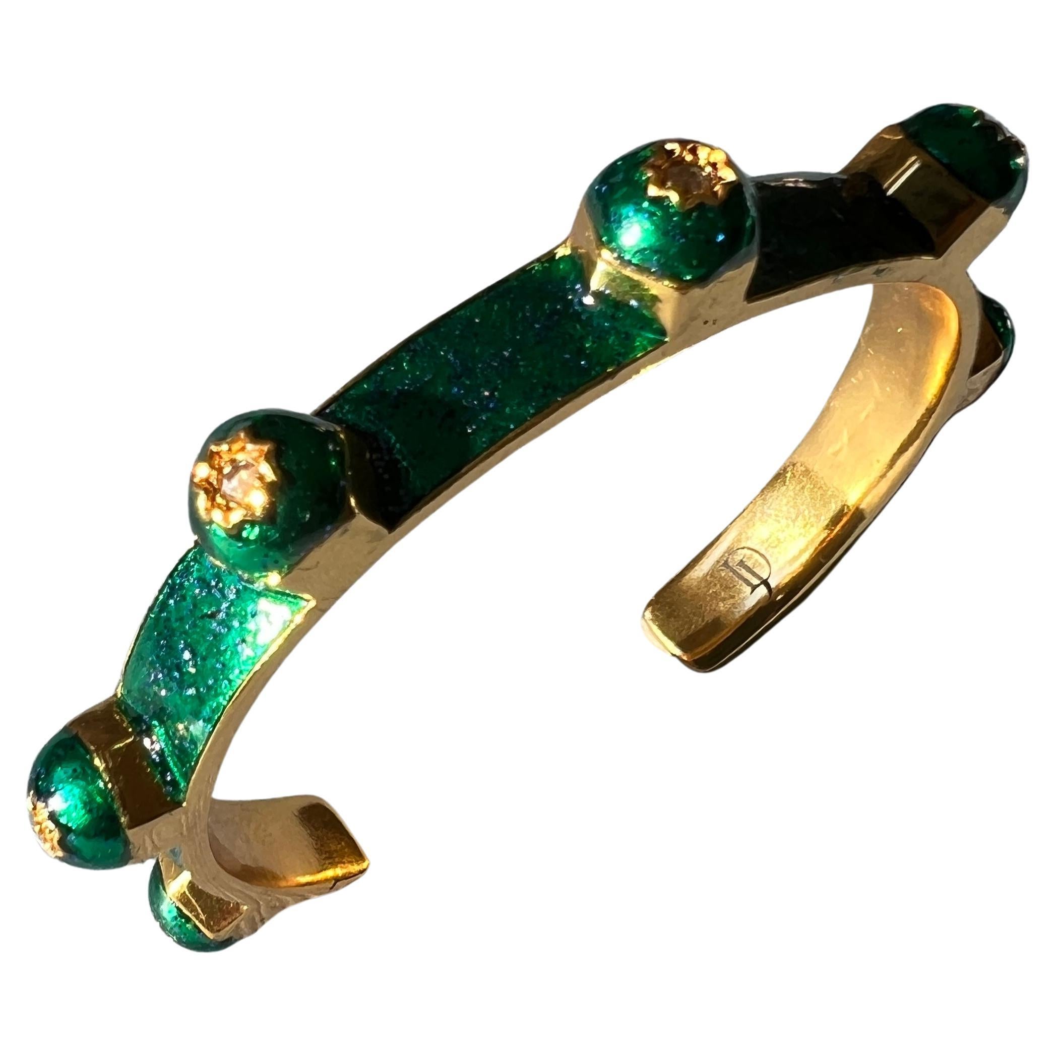 7 pieces White Diamond set in eightpointed stars on a stud cuff bangle, Enamelled in Emerald Green Glitter and 18 K Gold Plated Brass

Designer: J Dauphin

White diamonds are timeless symbols of purity, strength, and elegance. Known for their