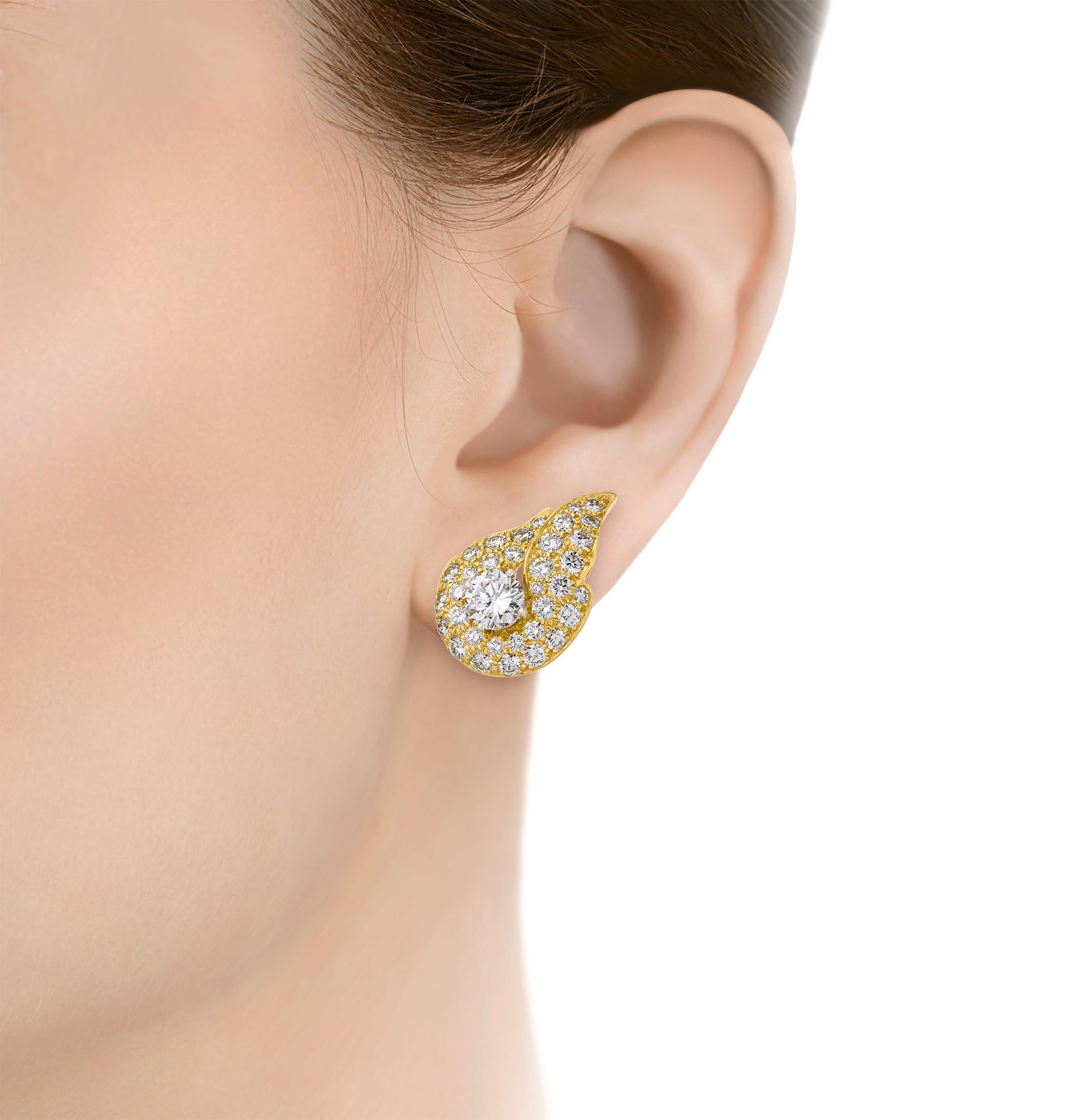 Timeless yet modern, these diamond earrings take the form of a flickering flame. Each earring centers a round brilliant-cut diamond, weighing 2.20 carats and 2.40 carats respectively, further elevated by pavé diamonds totaling 3.50 carats. Set in