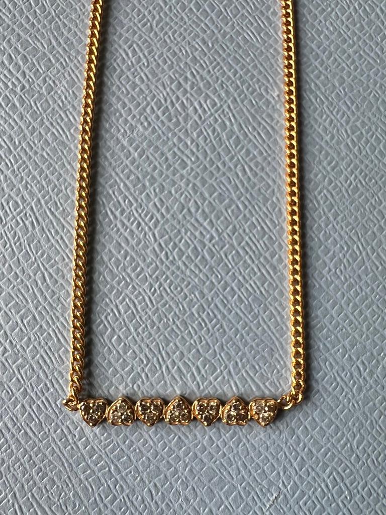21 pcs White Diamonds in a 7 pc Heart Necklace,  In each  Heart there is 3 pcs White Diamonds,  

Material: 18 K Gold Plated Silver

Length: Choker Length 15 inches
 
This necklace features seven hearts, each embedded with three white diamonds. The
