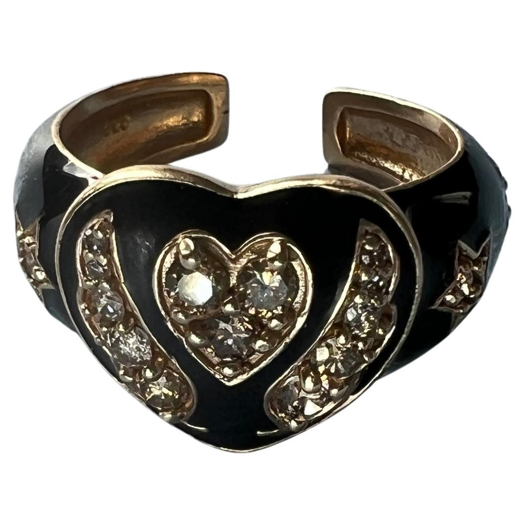White Diamond Heart Ring Black Enamel
This Ring is made in 14k Gold Plated Silver

Designer: J Dauphin

Heart Ring with several Single Cut White Diamonds made with Black Enamel, on the side of the stars it has two angel wings and on the band there