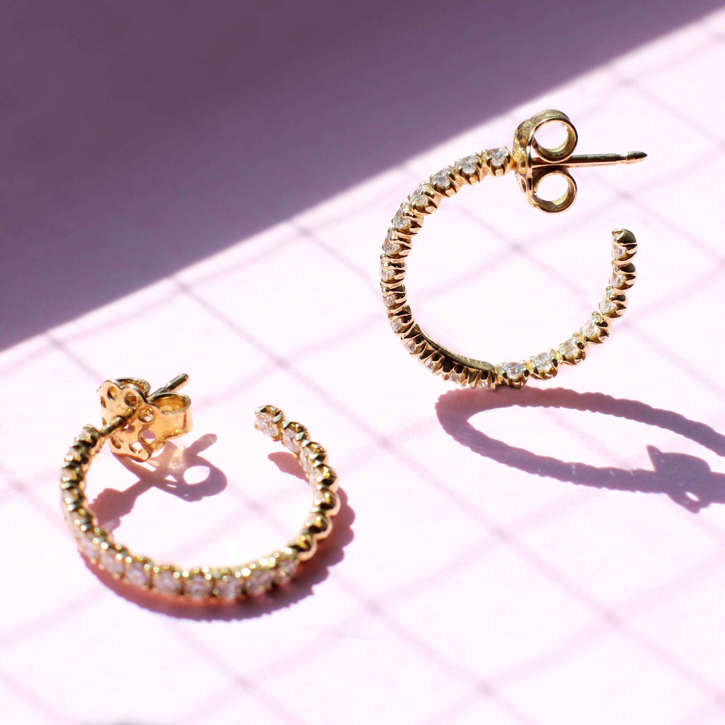 Glistening 18k yellow gold, white diamond ‘eternity’ hoops with a versatile and peculiar design that showcases diamonds set at the front and back for a glorious diamond-only view. These hoops will catch all the attention when worn solo, or be