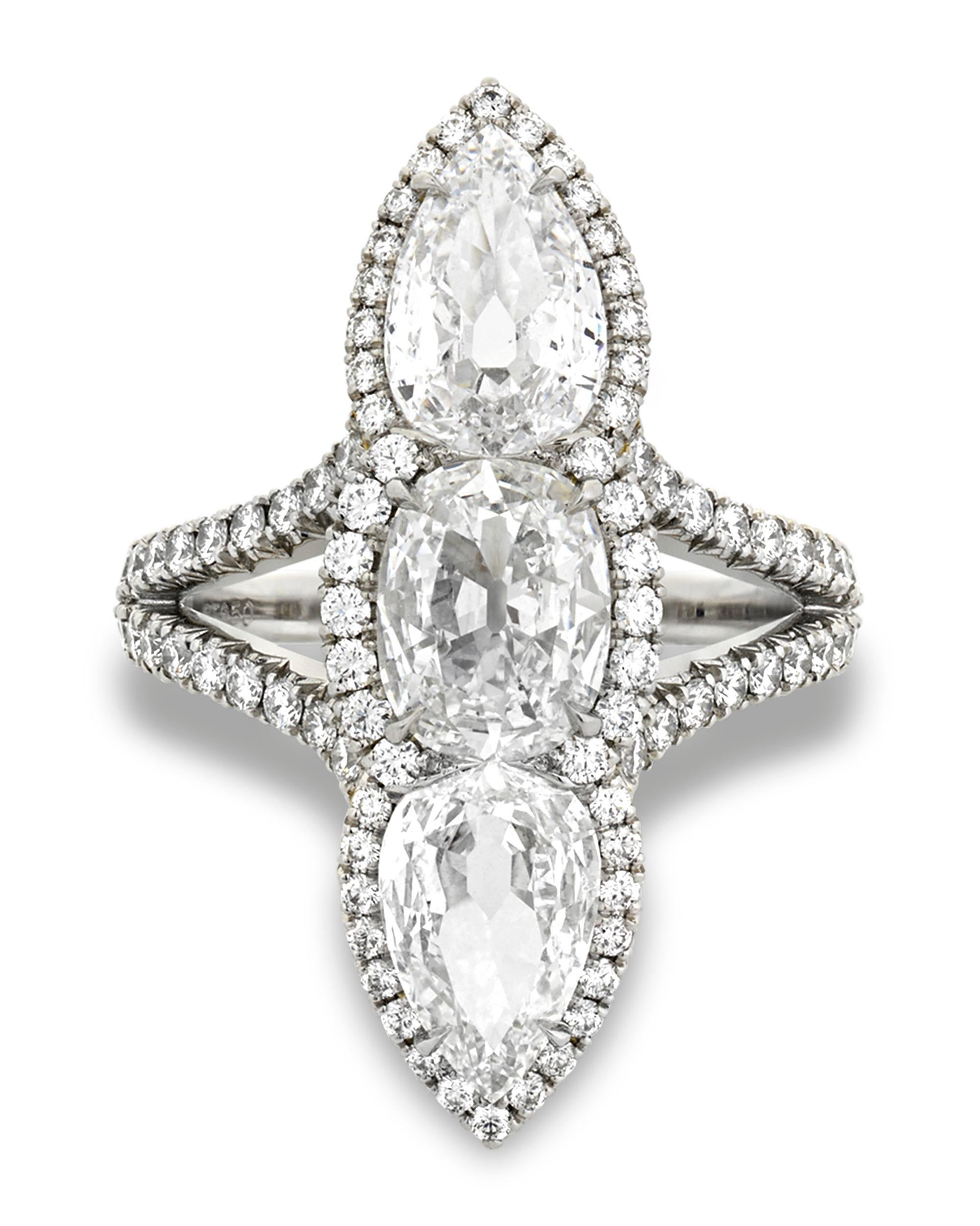 Three incredible, certified white diamonds totaling 3.04 carats are simply radiant in this three-stone North-South ring. The cushion-shaped center stone weighs 1.06 carats and displays a D color with VS2 clarity. The pear-shaped diamonds weigh a